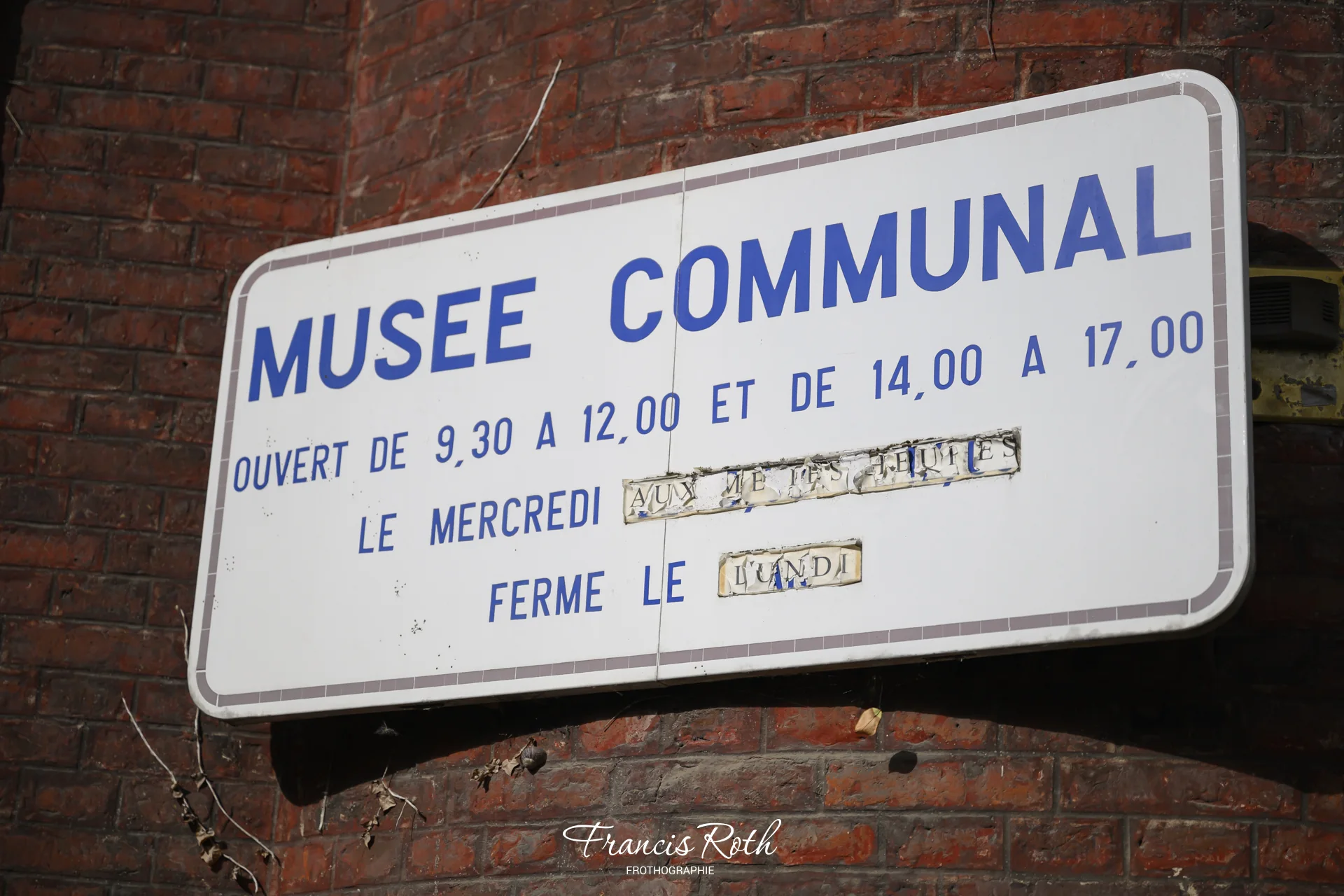 Ancienne plaque « Musée communal » avec les horaires d'ouverture, à Nivelles