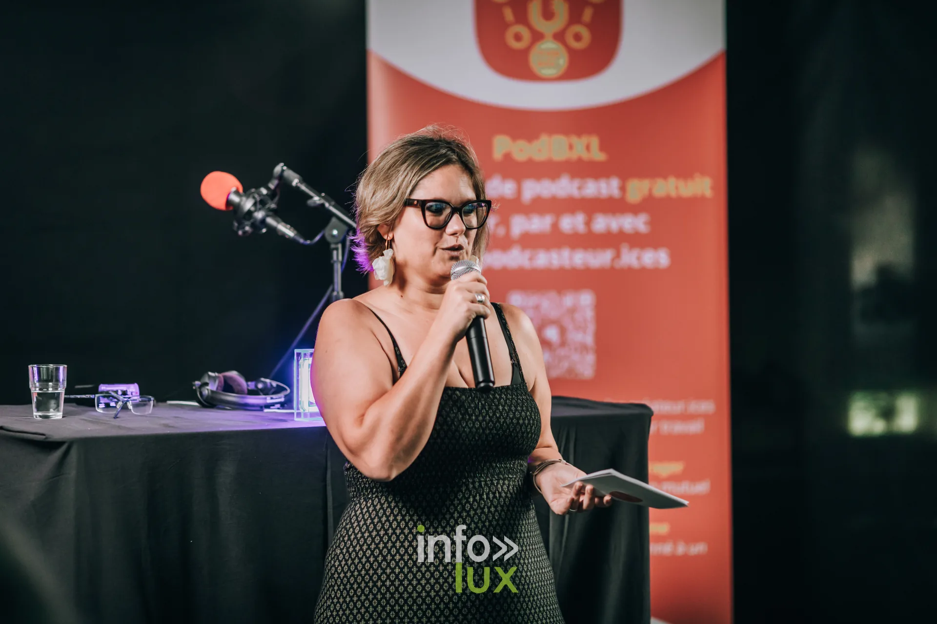 Podcasteuse au micro devant le kakemono PodBXL lors du festival a Evere