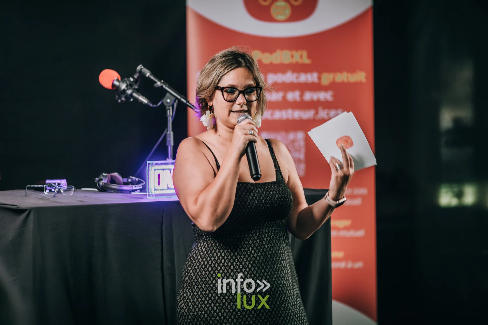 Creatrice de podcast presentant un ouvrage au micro sur la scene de PodBXL 2026