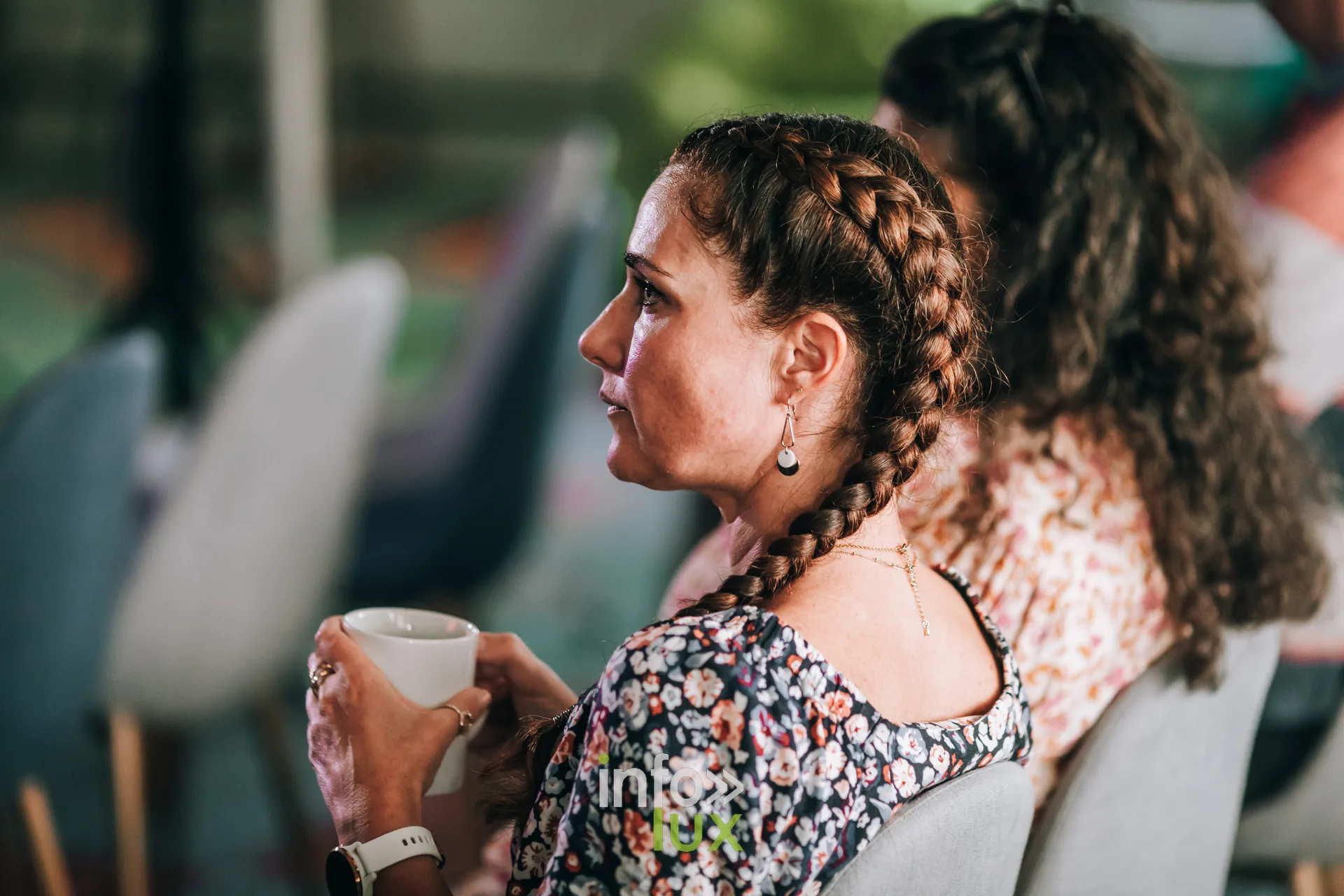 Participante tenant une tasse de cafe pendant une ecoute au festival PodBXL