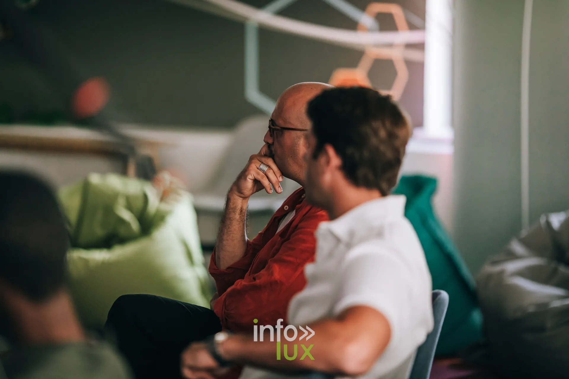 Deux participants assis sur des poufs pendant une session du festival PodBXL