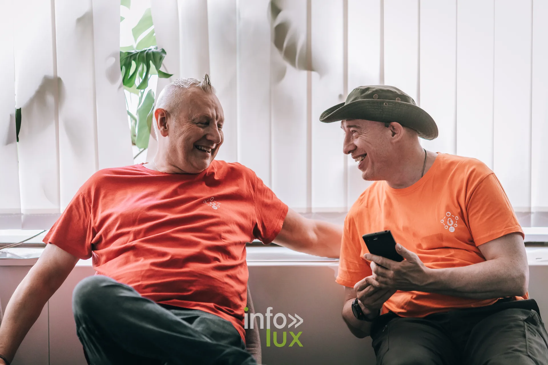 Deux organisateurs en t-shirt orange discutant pendant le festival PodBXL