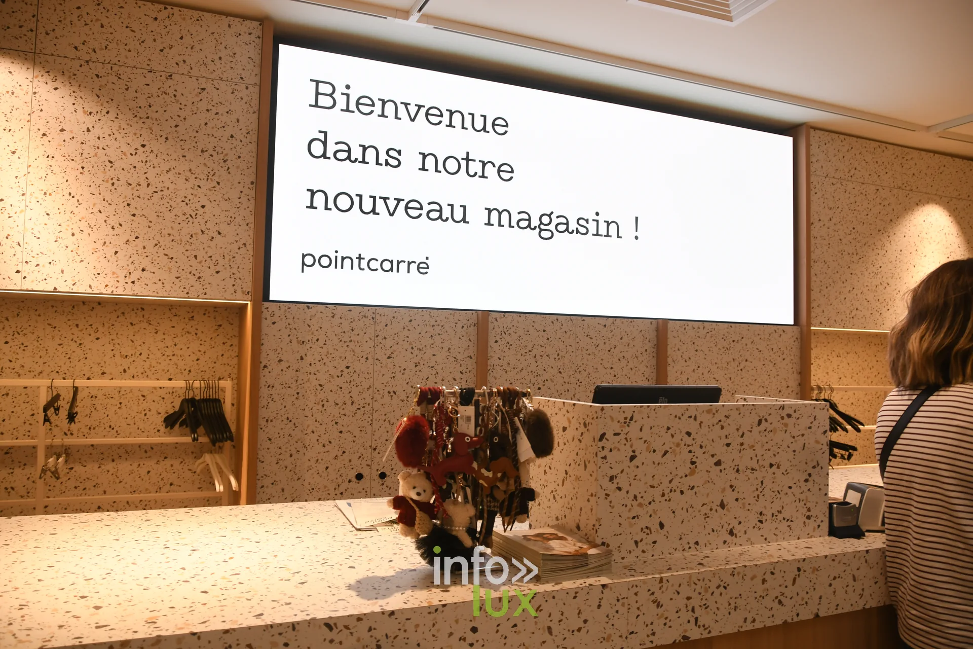 Écran « Bienvenue dans notre nouveau magasin ! » au-dessus de la caisse du PointCarré de Recogne