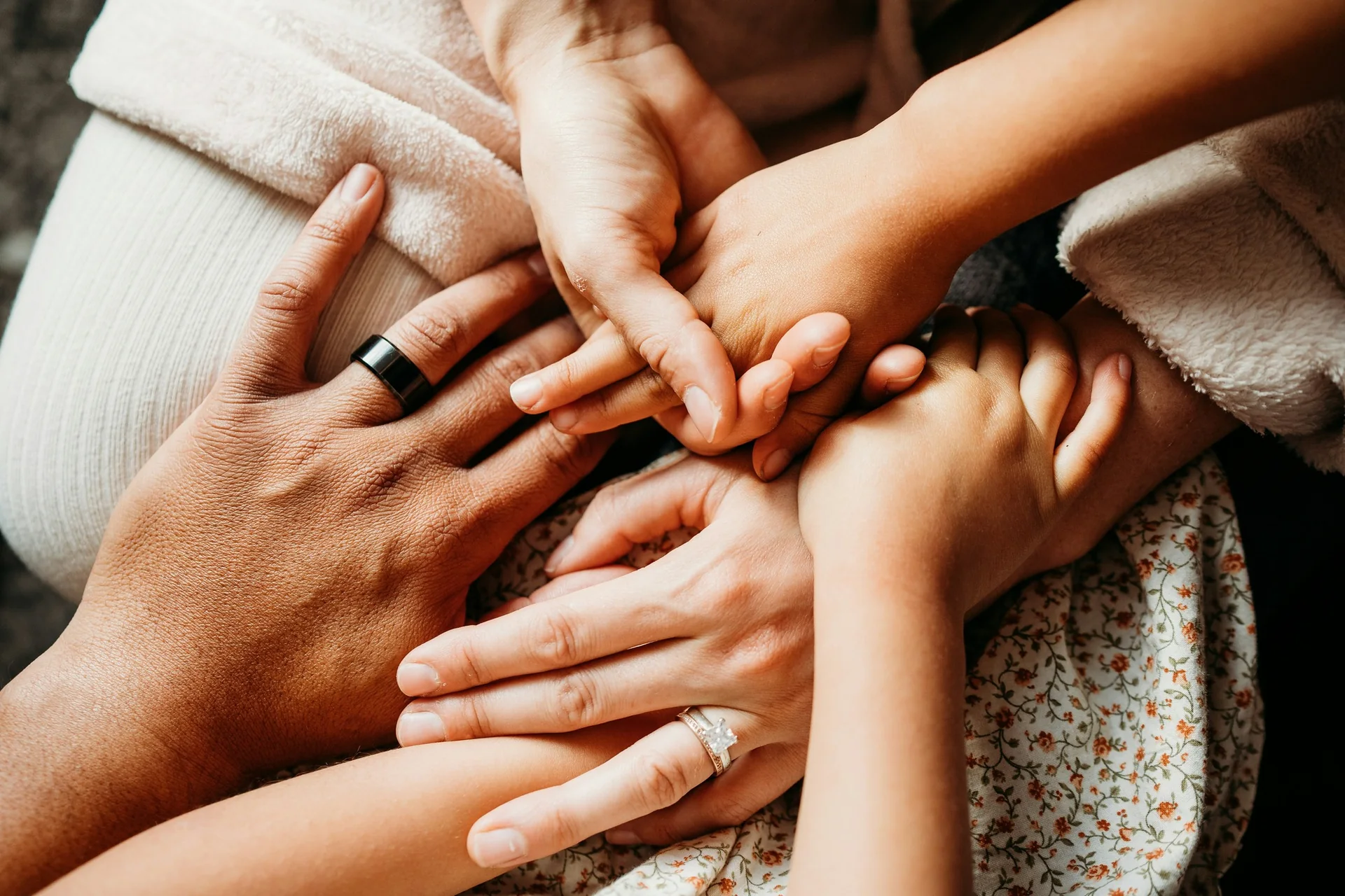 Plusieurs mains d’adultes et d’enfants superposées, symbole du lien familial