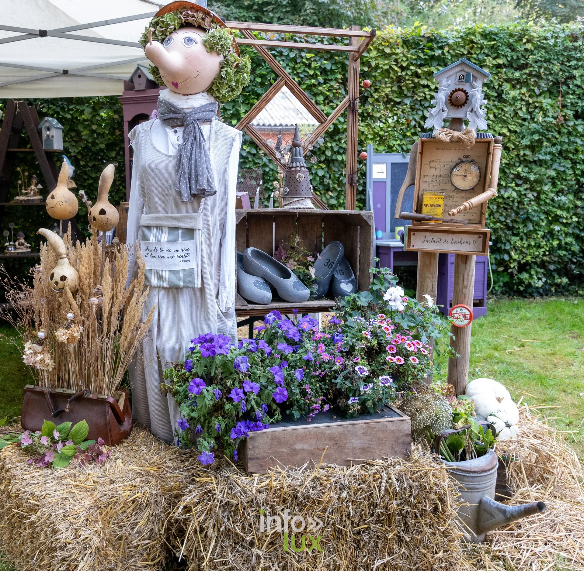 Un épouvantail décoré de fleurs, de paille et d’objets anciens