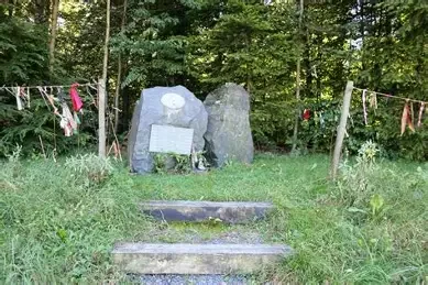 Monument en pierre orne d'une tete d'indien et entoure d'attrape-reves, en hommage aux combattants amerindiens, a Recogne pres de Bastogne