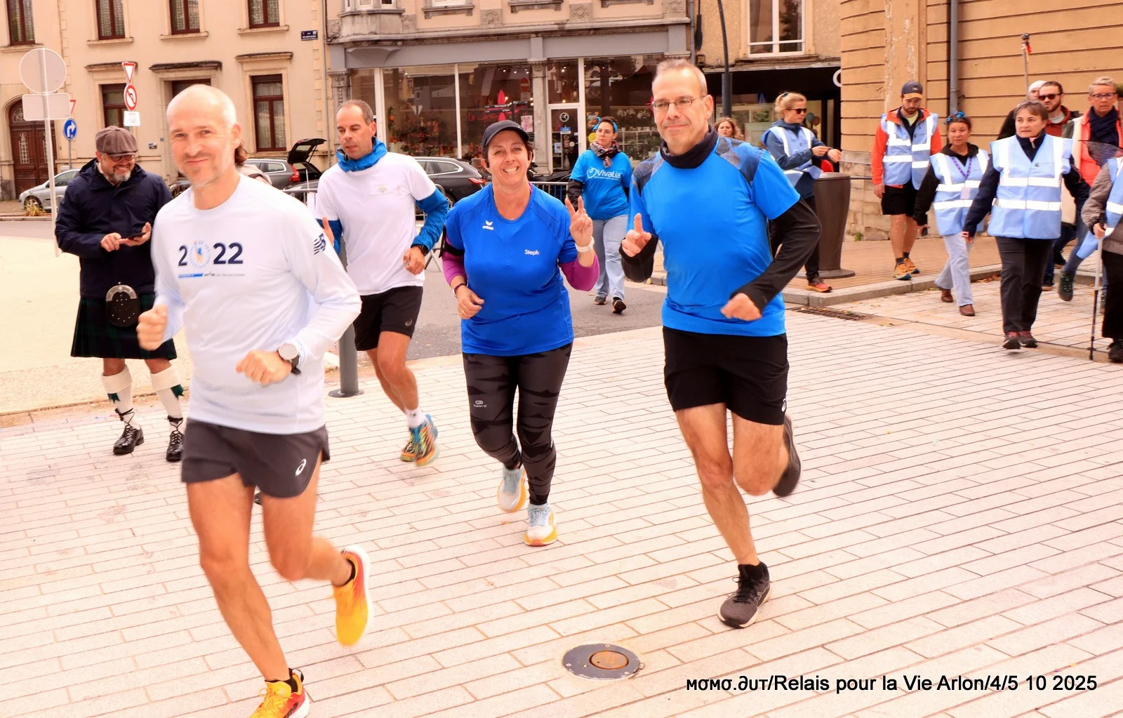 Des coureurs souriants en tee-shirts bleus sur le circuit du Relais pour la Vie d’Arlon