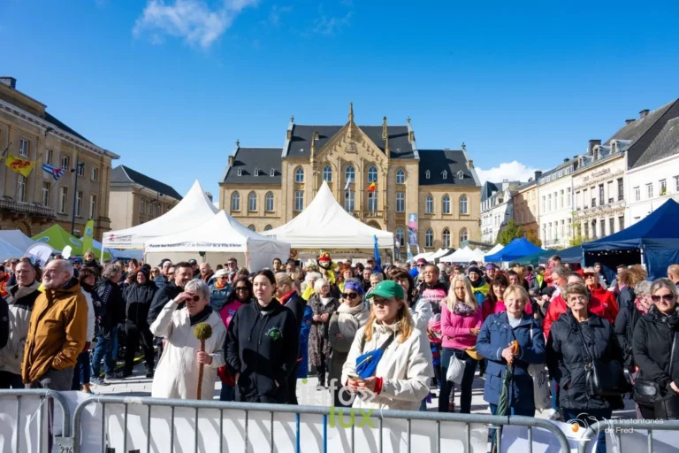 La foule du Relais pour la Vie sur la place Léopold à Arlon, devant le palais, tentes blanches et participants en tee-shirts