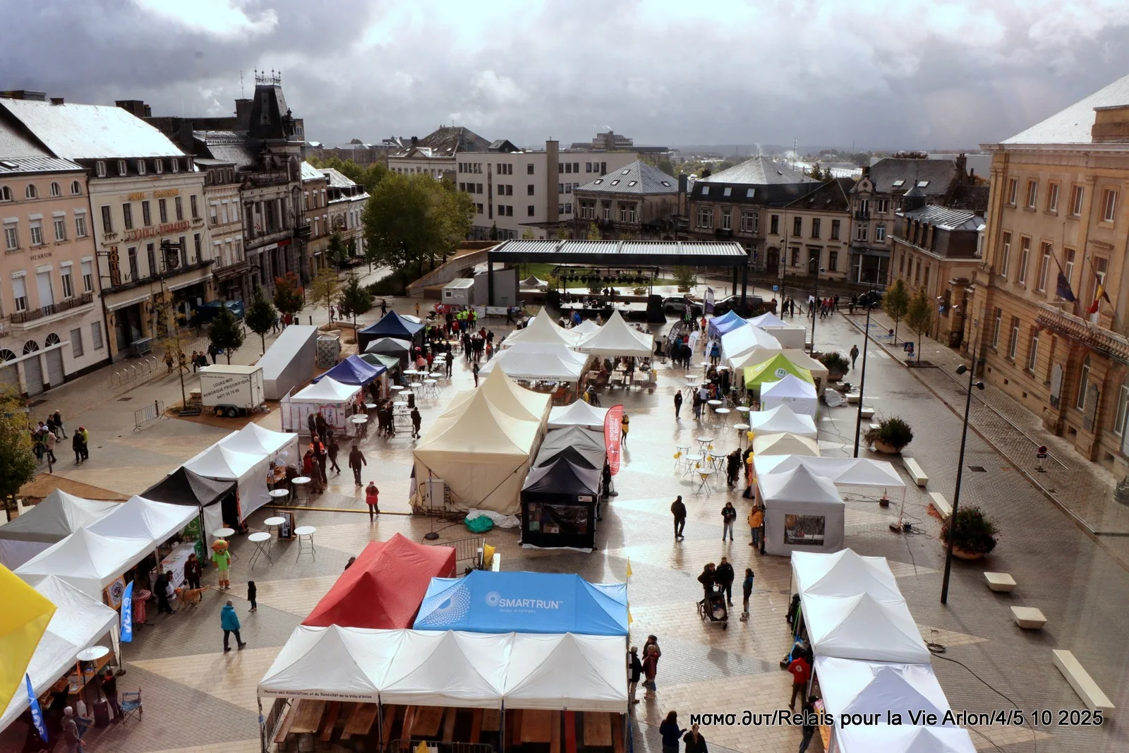 Vue en hauteur du village du Relais pour la Vie sur la place Léopold à Arlon : tentes, scène et marcheurs