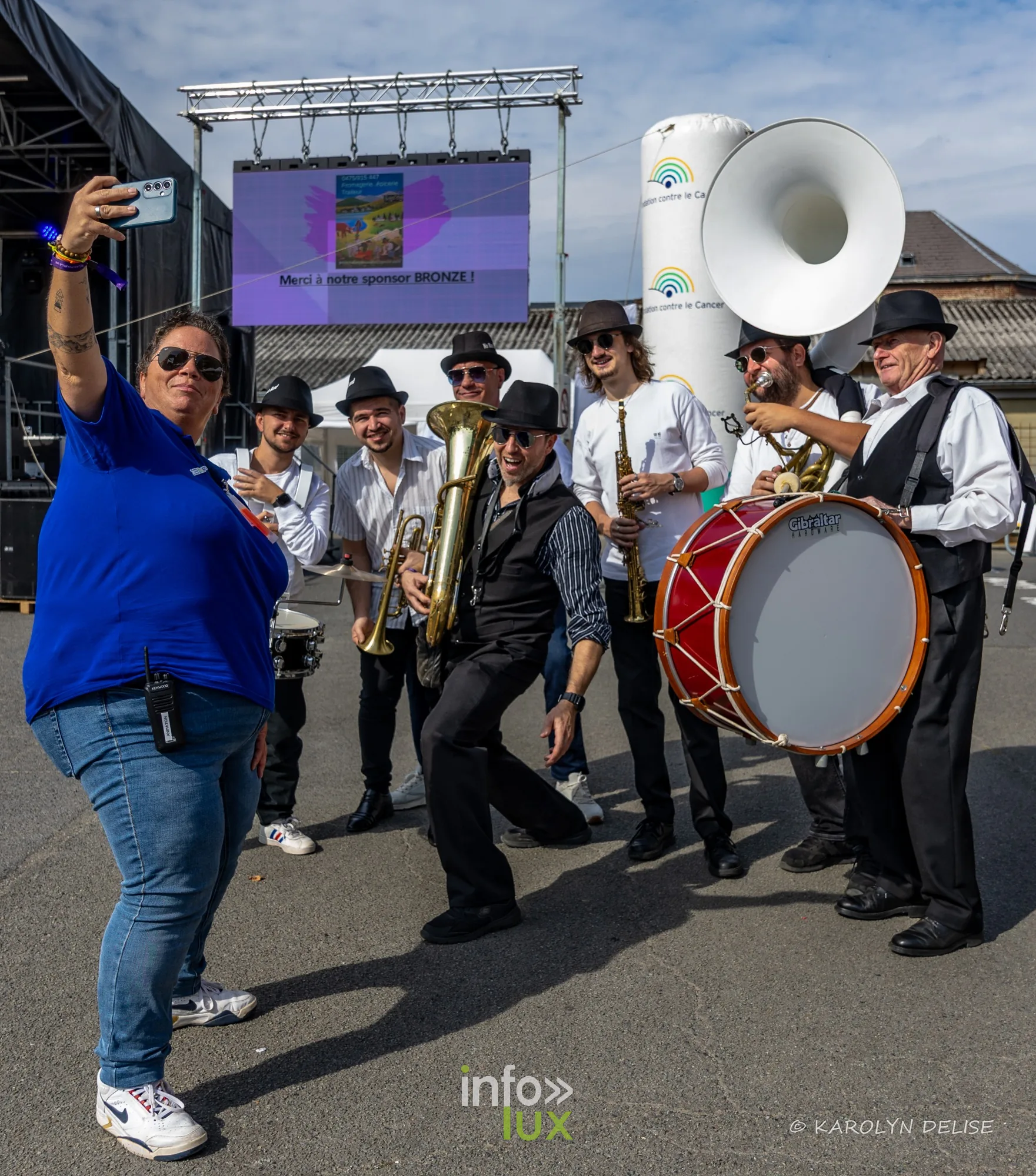 Fanfare en chemise blanche et chapeau noir au village du Relais, Relais pour la Vie de Nivelles 2026