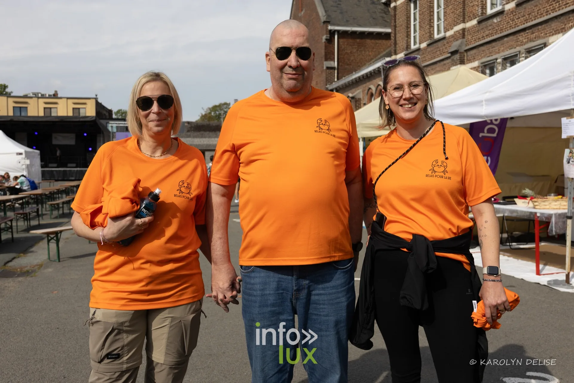 Équipe en t-shirt orange au motif de crabe au village du Relais, Relais pour la Vie de Nivelles 2026