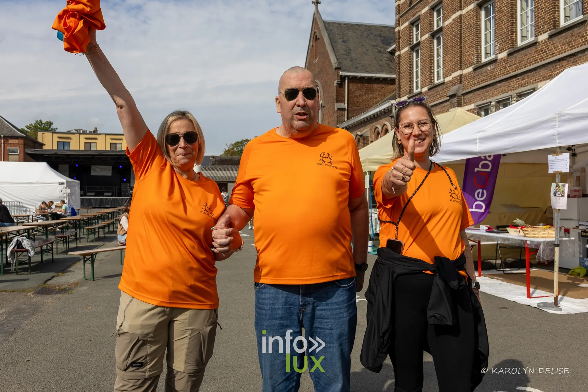 Équipe en t-shirt orange au motif de crabe au village du Relais, Relais pour la Vie de Nivelles 2026