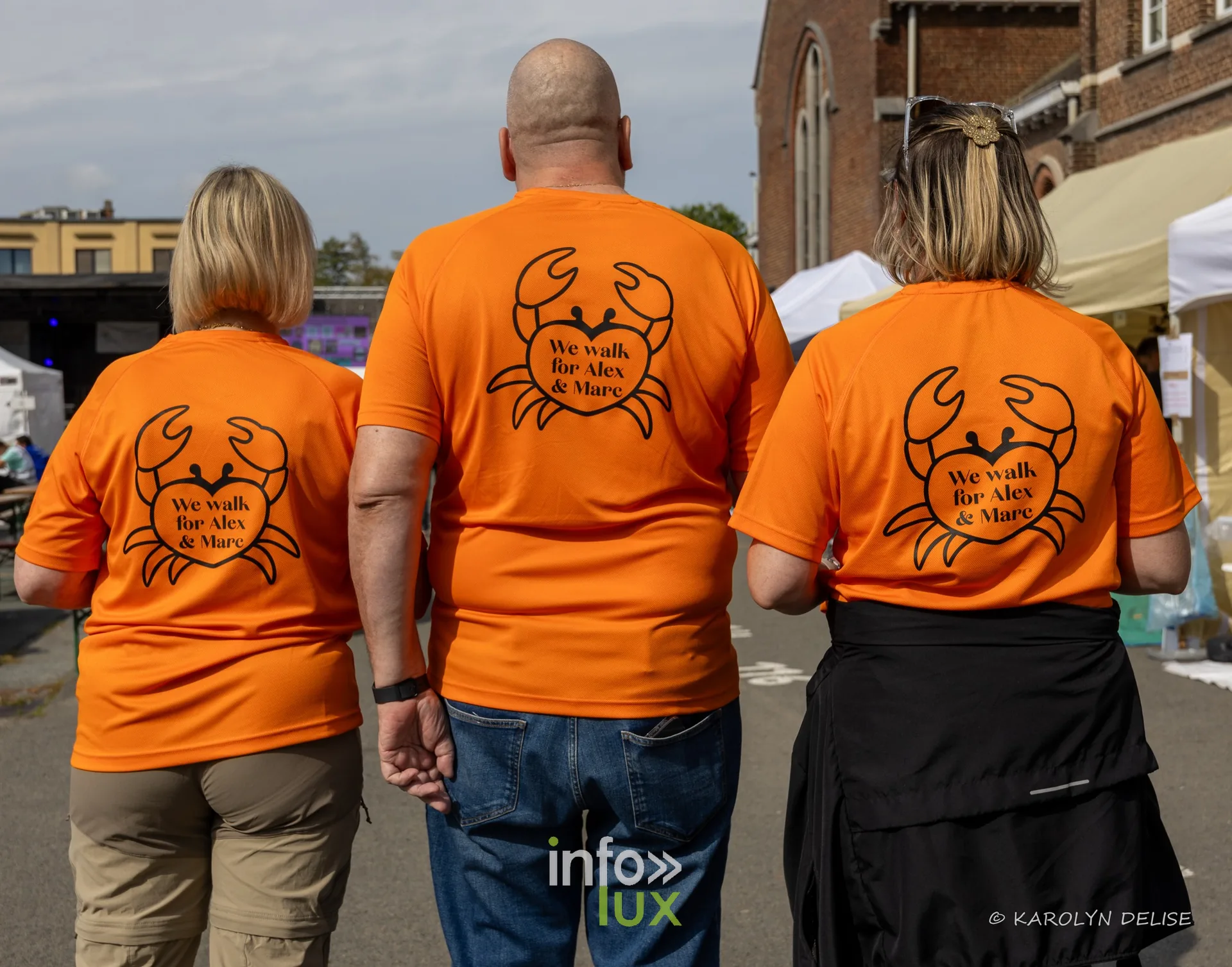 Équipe en t-shirt orange au motif de crabe au village du Relais, Relais pour la Vie de Nivelles 2026