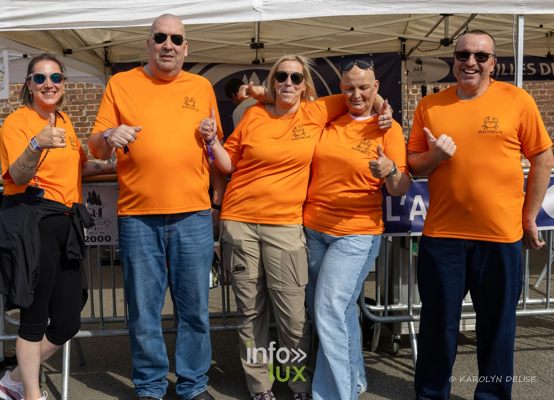 Équipe en t-shirt orange au motif de crabe au village du Relais, Relais pour la Vie de Nivelles 2026