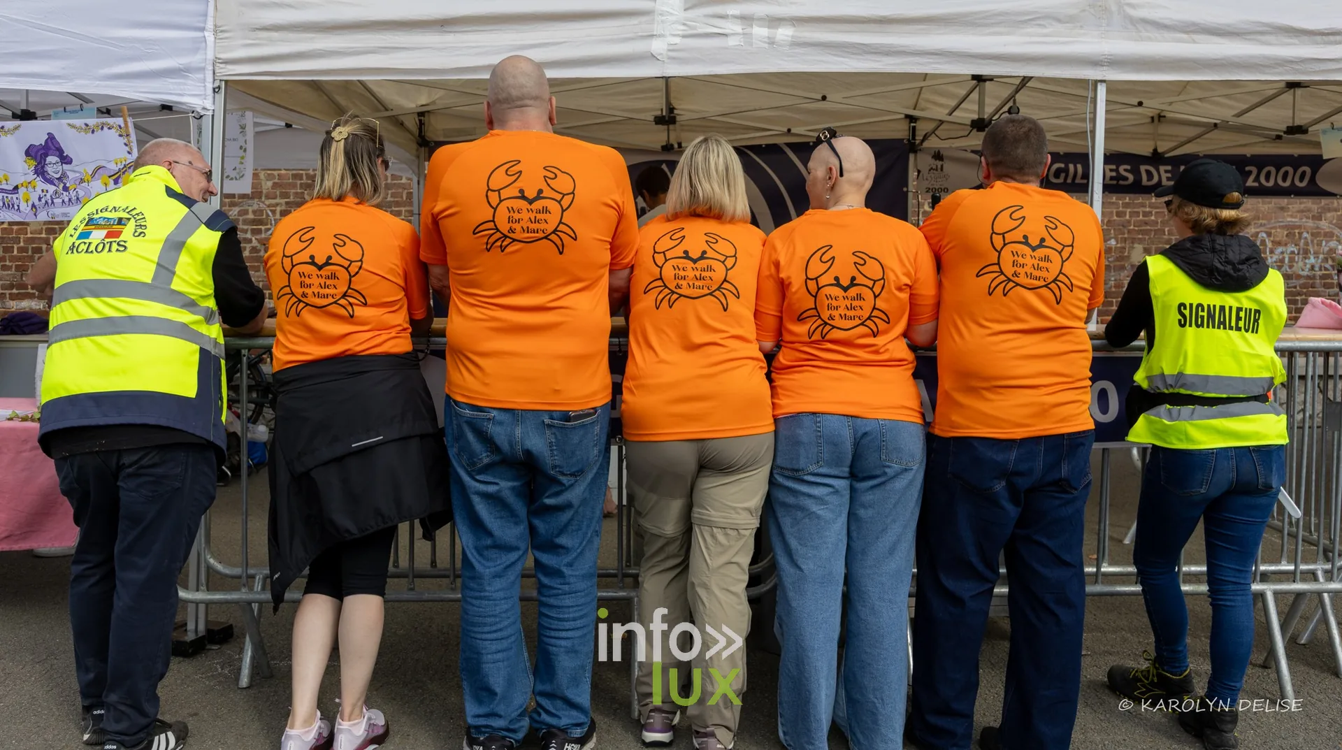 Équipe en t-shirt orange au motif de crabe au village du Relais, Relais pour la Vie de Nivelles 2026