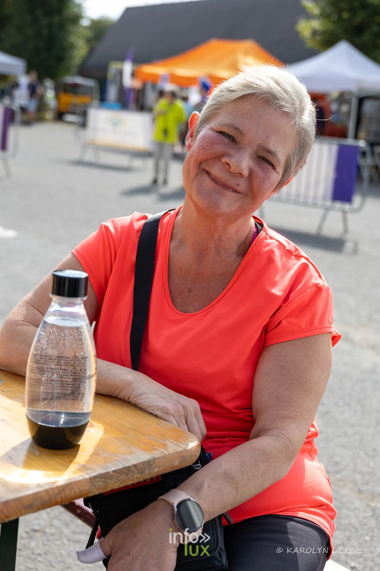 Participante souriante à une table du village, Relais pour la Vie de Nivelles 2026