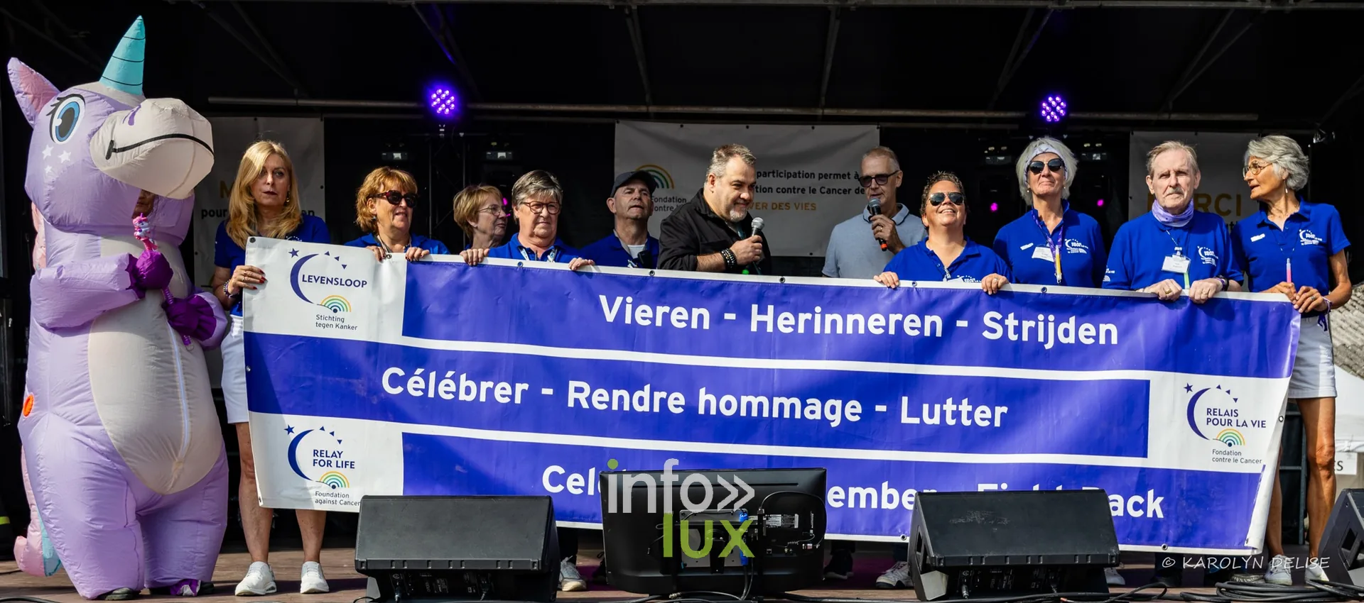 Banderole « Célébrer – Rendre hommage – Lutter » sur la scène, cérémonie d’ouverture, Relais pour la Vie de Nivelles 2026