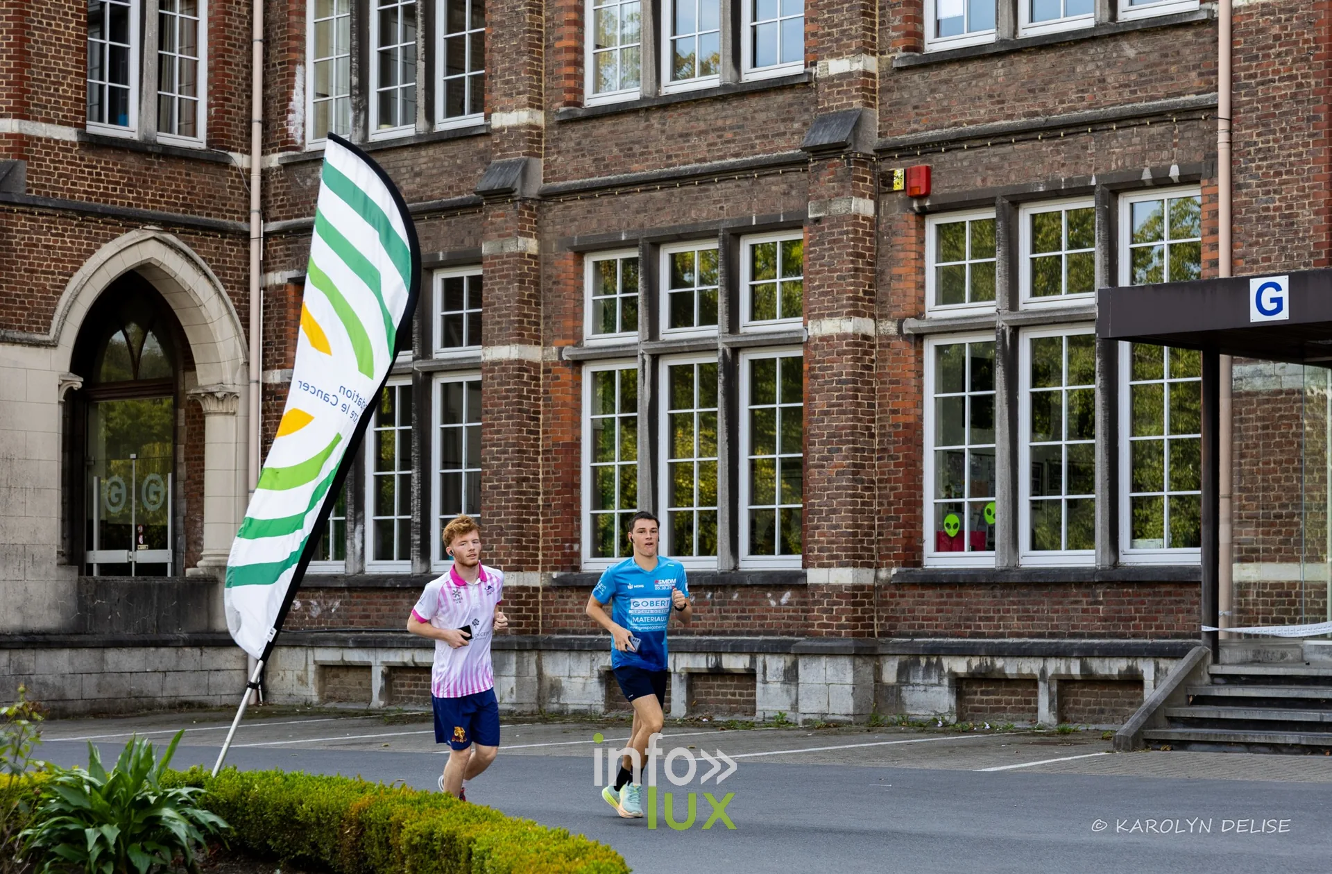 Coureurs et marcheurs devant la façade du collège sur le circuit, Relais pour la Vie de Nivelles 2026