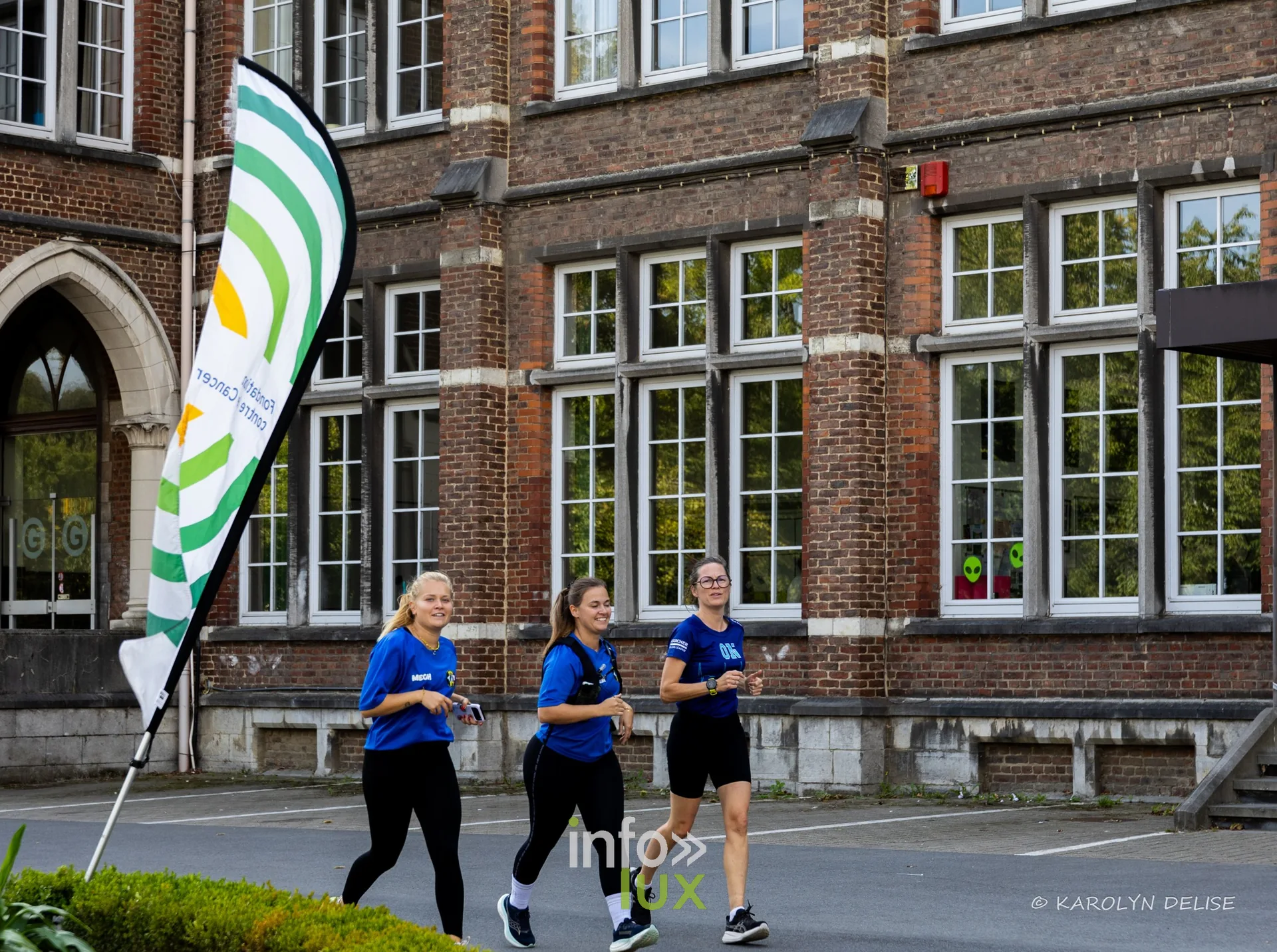 Coureurs et marcheurs devant la façade du collège sur le circuit, Relais pour la Vie de Nivelles 2026