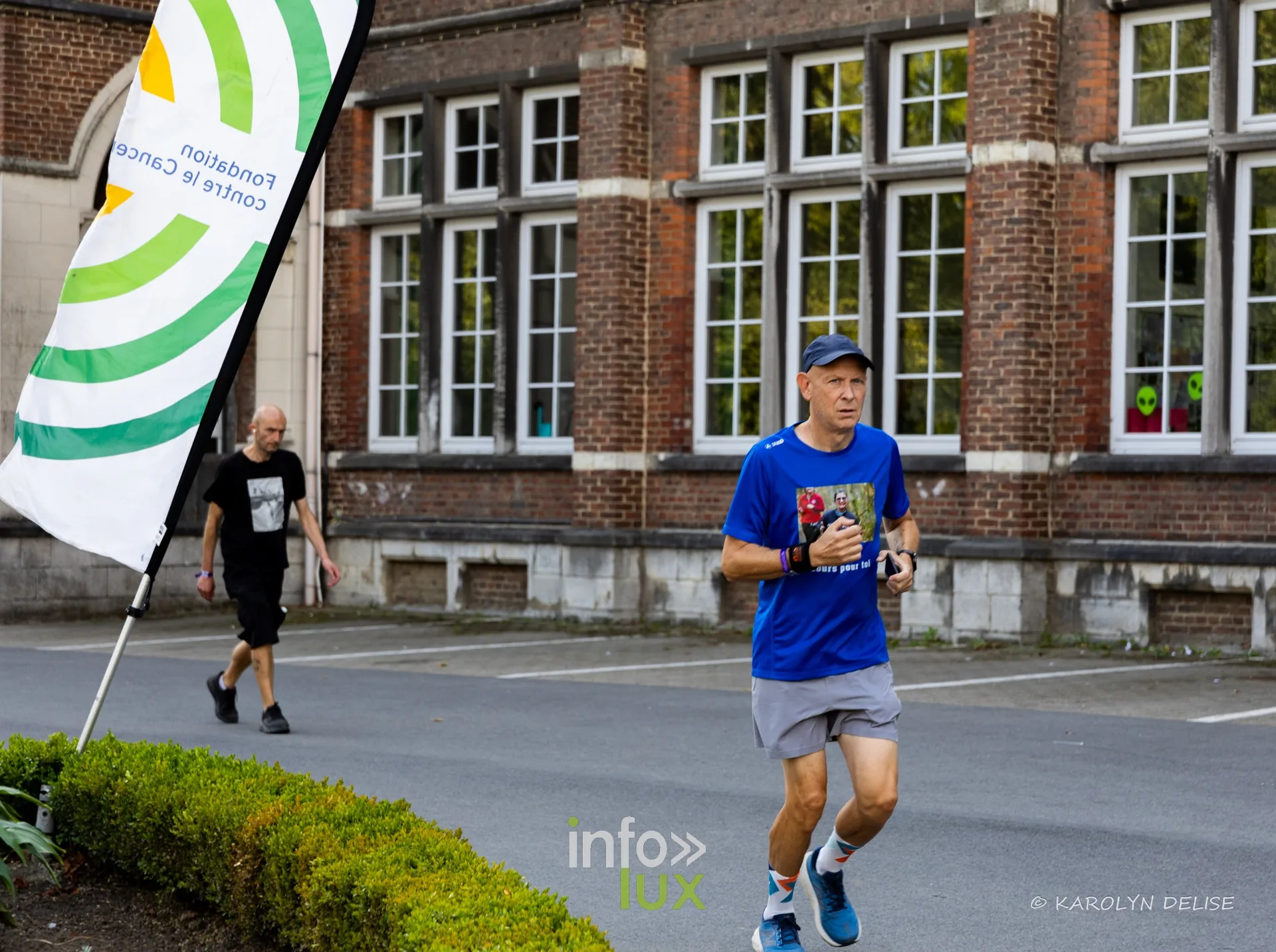 Coureurs et marcheurs devant la façade du collège sur le circuit, Relais pour la Vie de Nivelles 2026
