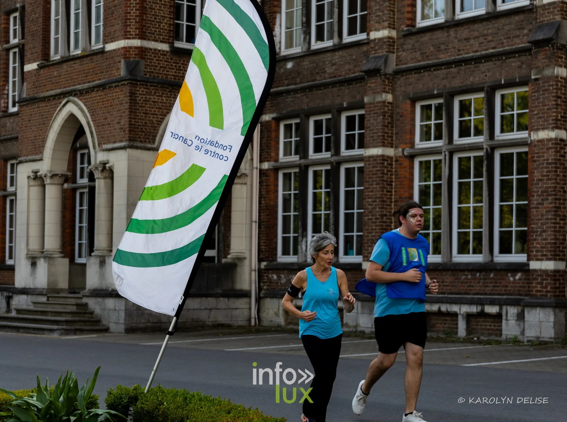 Coureurs et marcheurs devant la façade du collège sur le circuit, Relais pour la Vie de Nivelles 2026