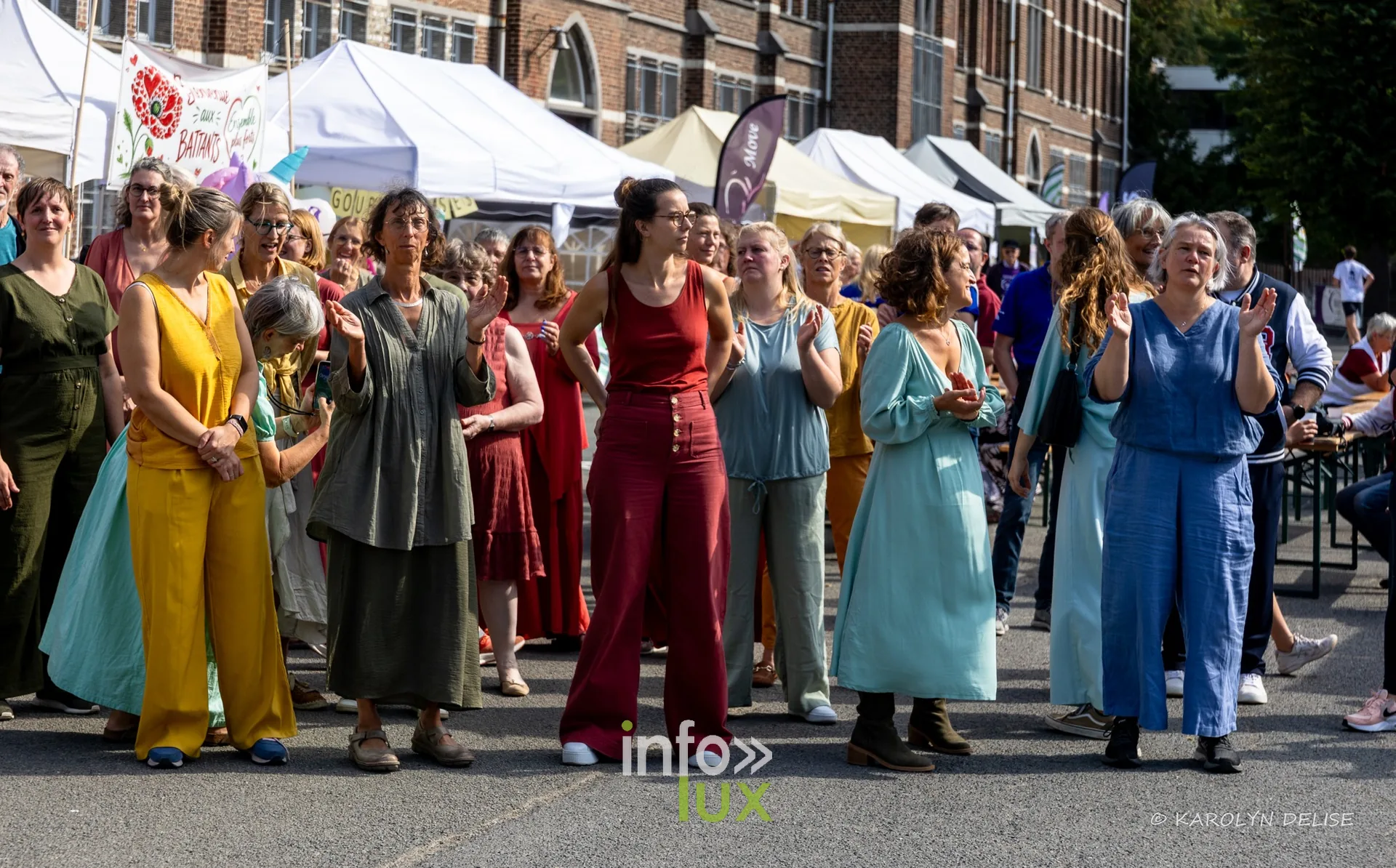 Chorale en robes colorées et public, cérémonie de clôture, Relais pour la Vie de Nivelles 2026
