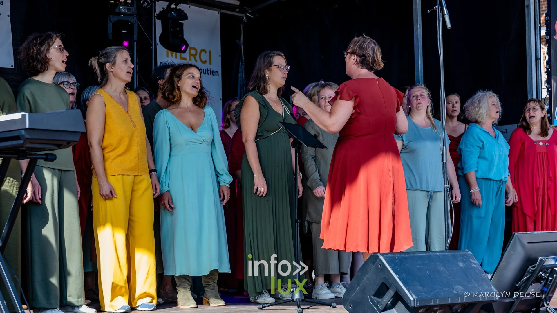 Chorale en robes colorées sur la scène, cérémonie de clôture, Relais pour la Vie de Nivelles 2026
