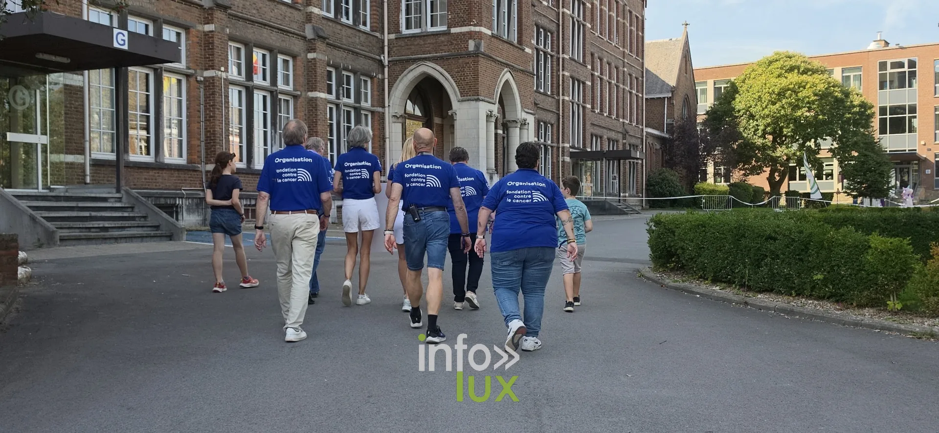 Bénévoles en t-shirt bleu devant le collège, Relais pour la Vie de Nivelles 2026
