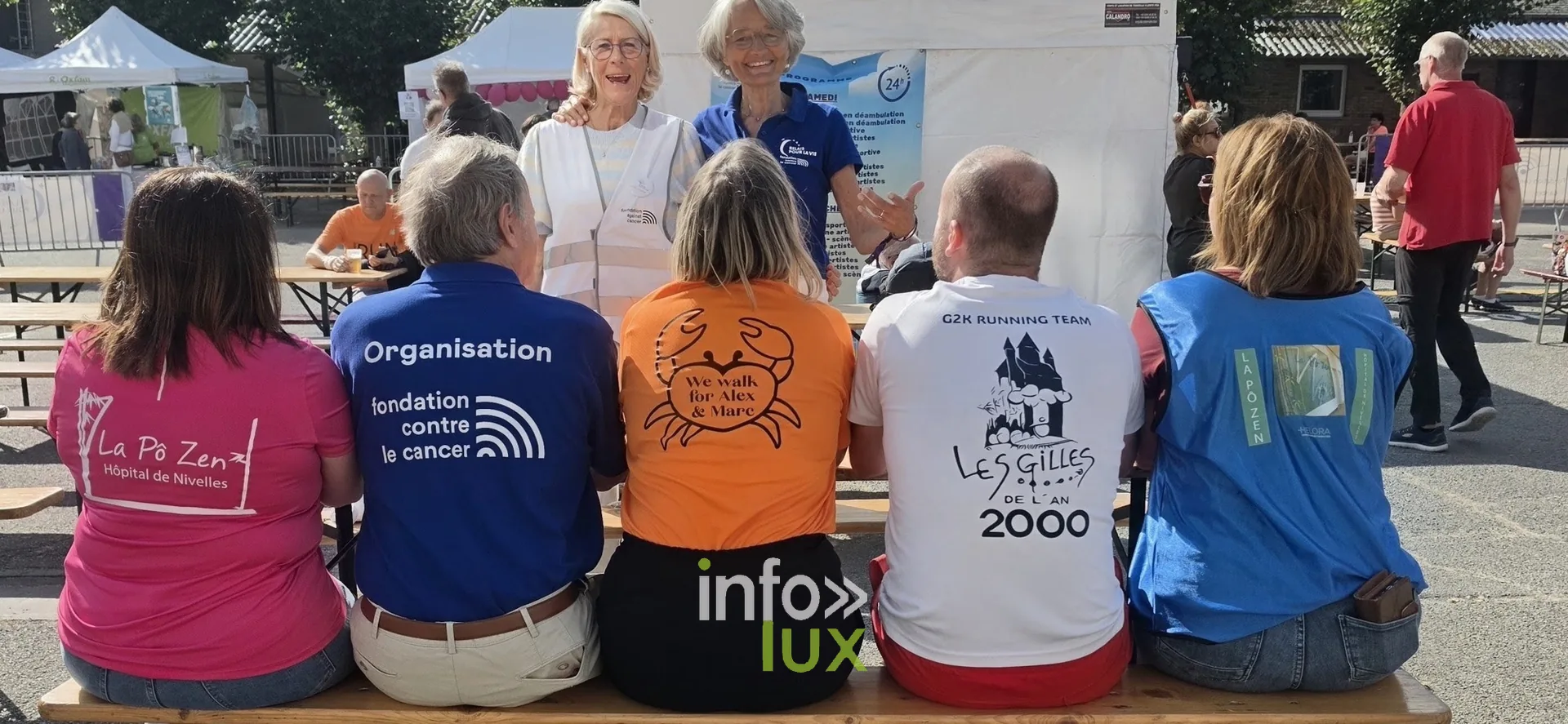 Participants de plusieurs équipes assis sur un banc, vus de dos, Relais pour la Vie de Nivelles 2026
