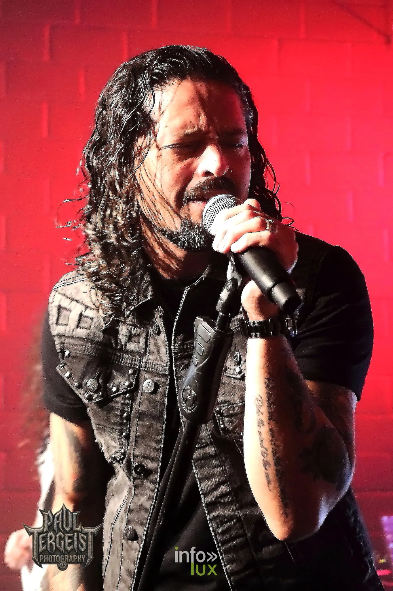 Ronnie Romero au chant sous une lumière rouge au Rockfabrik en 2024