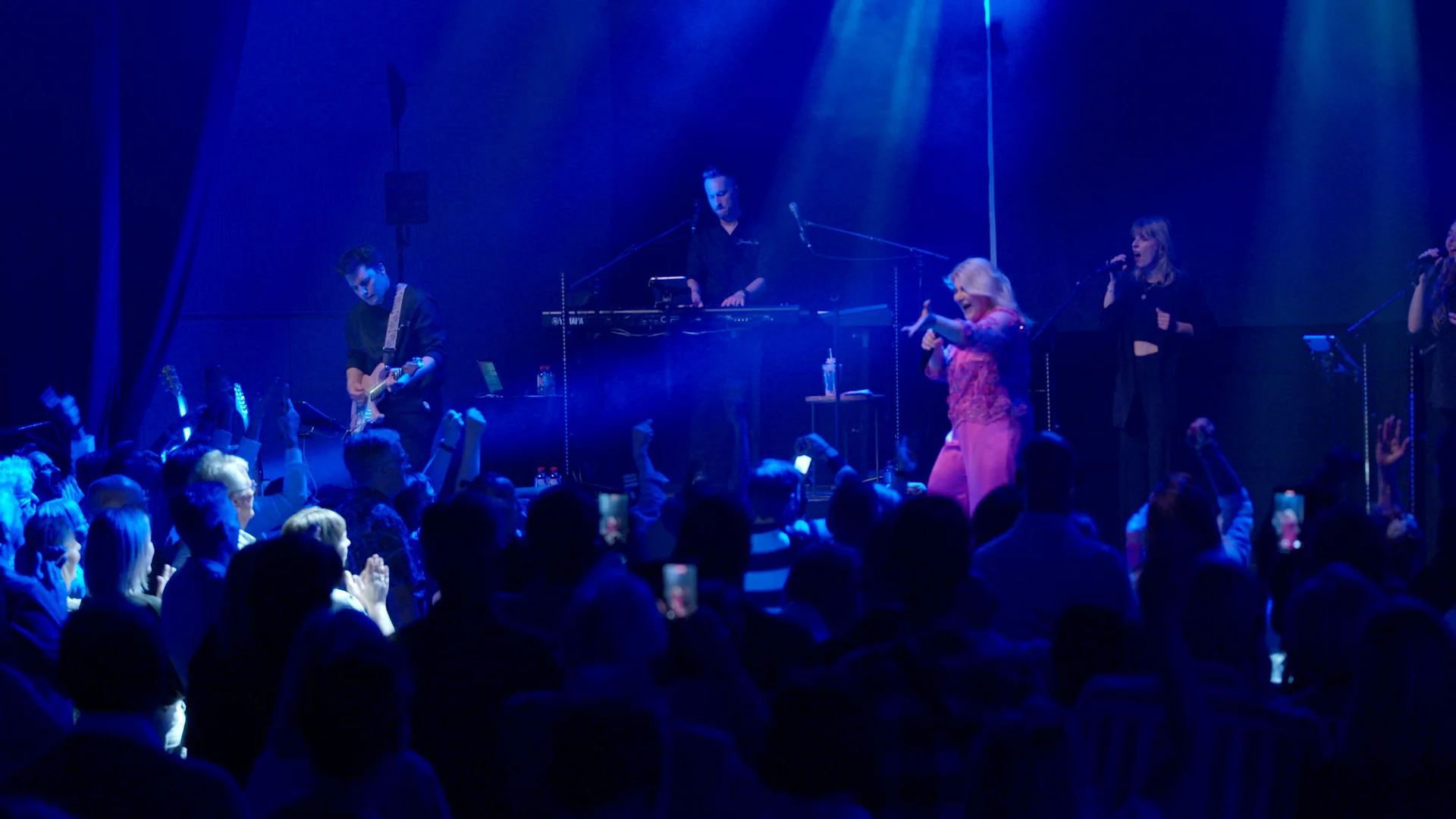 Sandra Kim en concert avec son band, salle debout