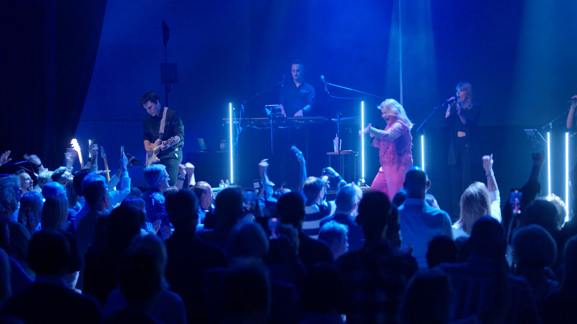 Sandra Kim en concert avec son band, le public debout