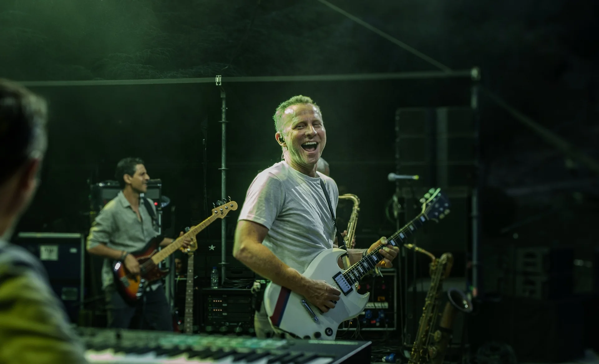 Sinclair sur scène en 2025, guitare blanche, entouré de ses musiciens