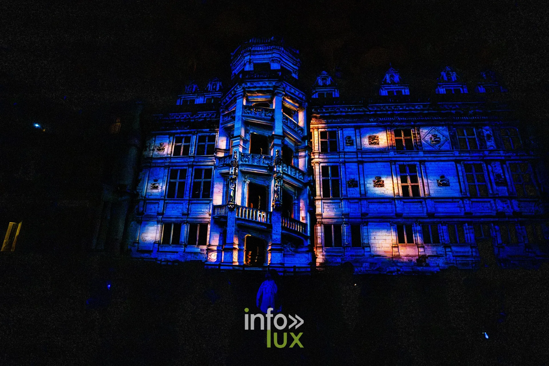 Façade à l'escalier du château de Blois colorée en bleu par le mapping