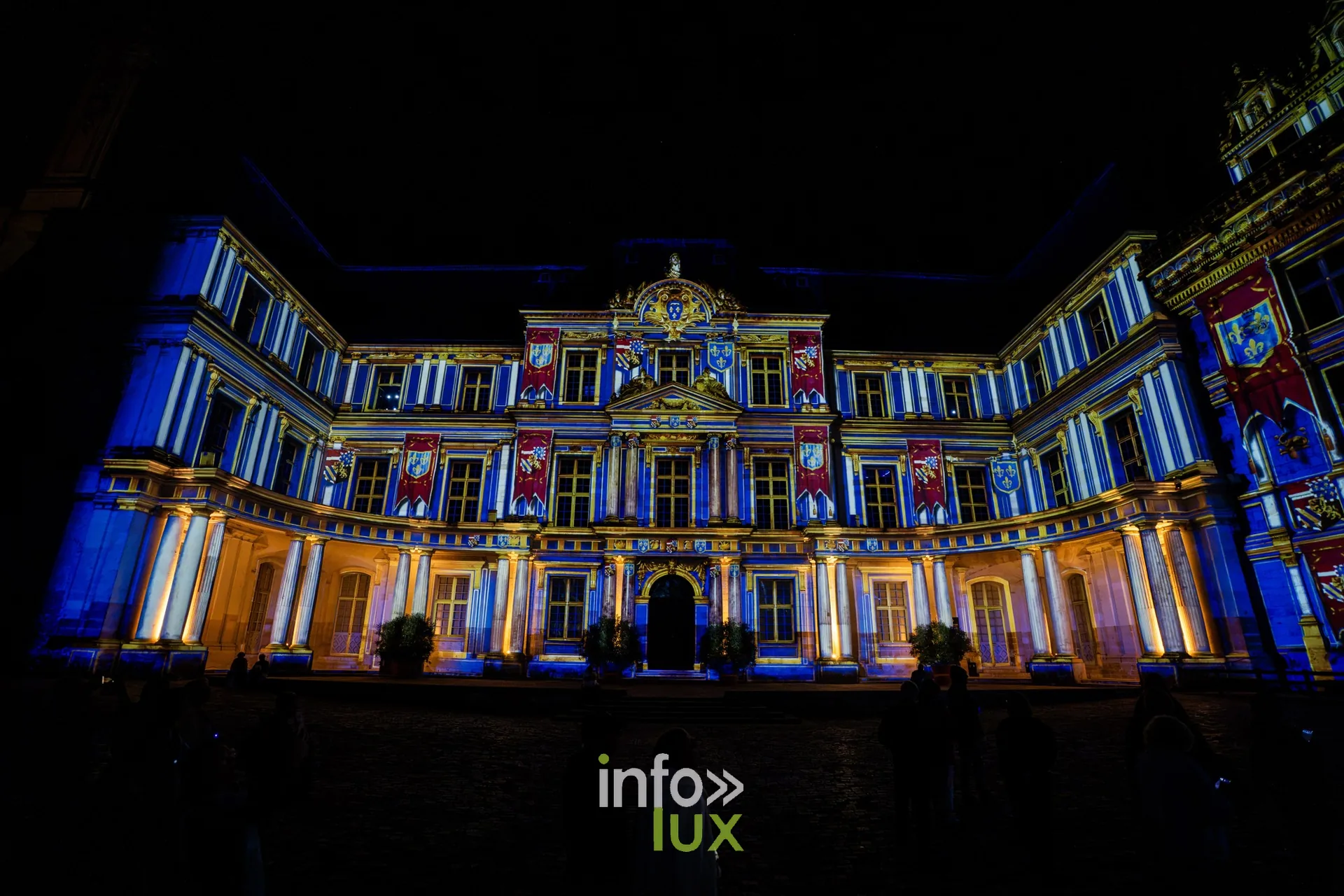 Façade du château de Blois ornée de blasons projetés en bleu et or