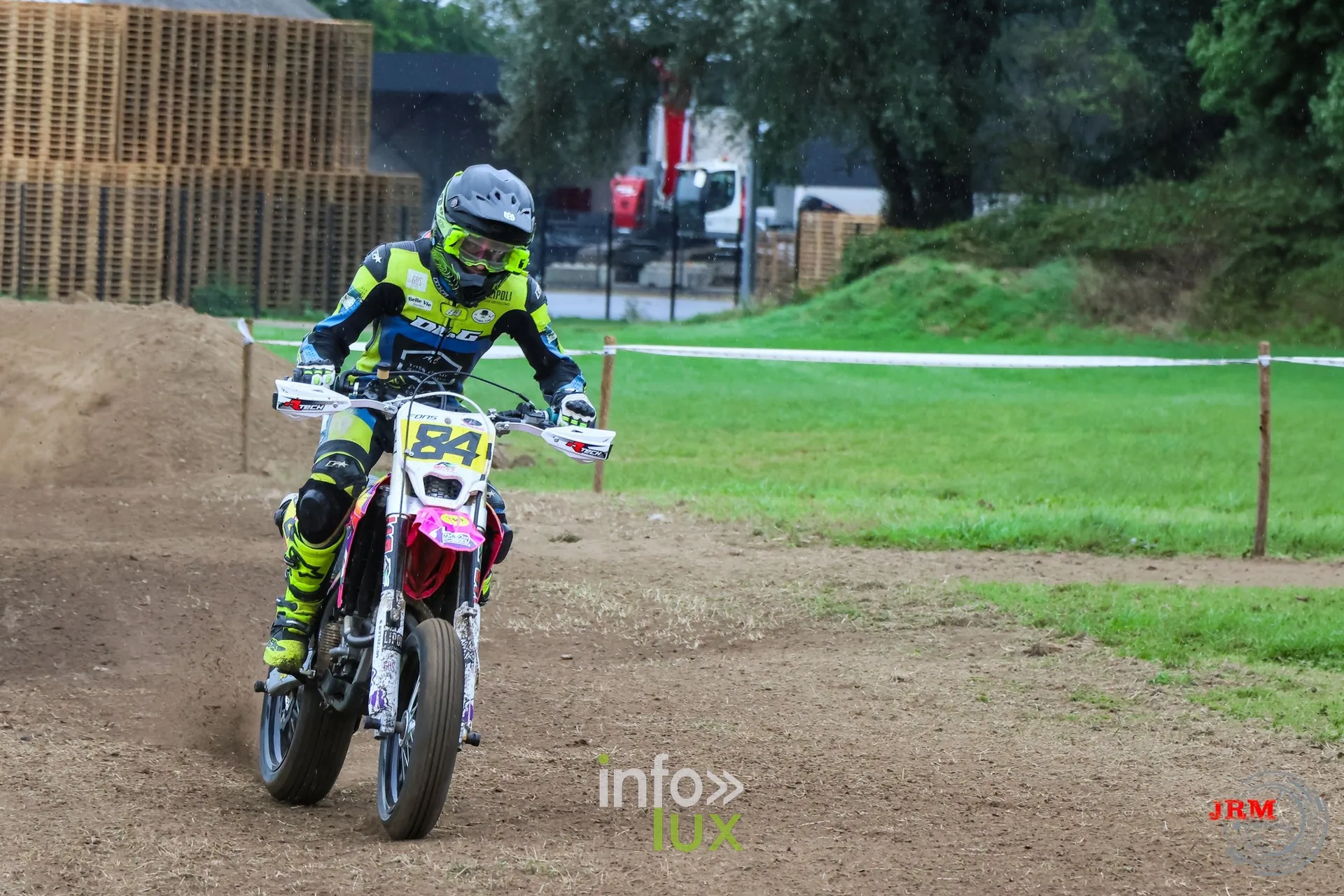 Supermotard de Battice 2026, Herve (province de Liège) : pilote n°84 sur une moto rose et jaune dans la partie terre, piste encore sèche