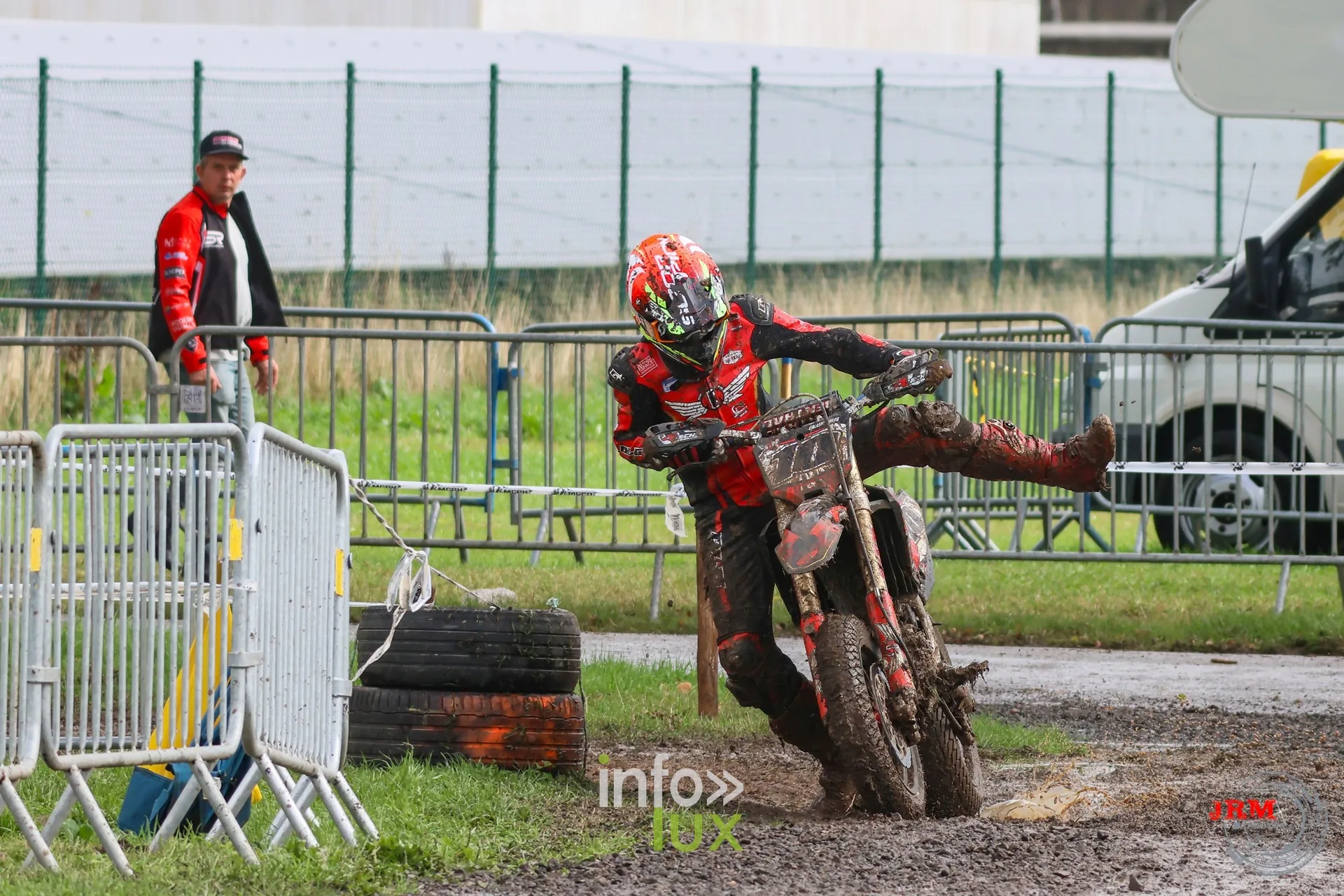 Supermotard de Battice 2026, Herve (province de Liège) : pilote pied en avant dans un virage boueux, le long des barrières