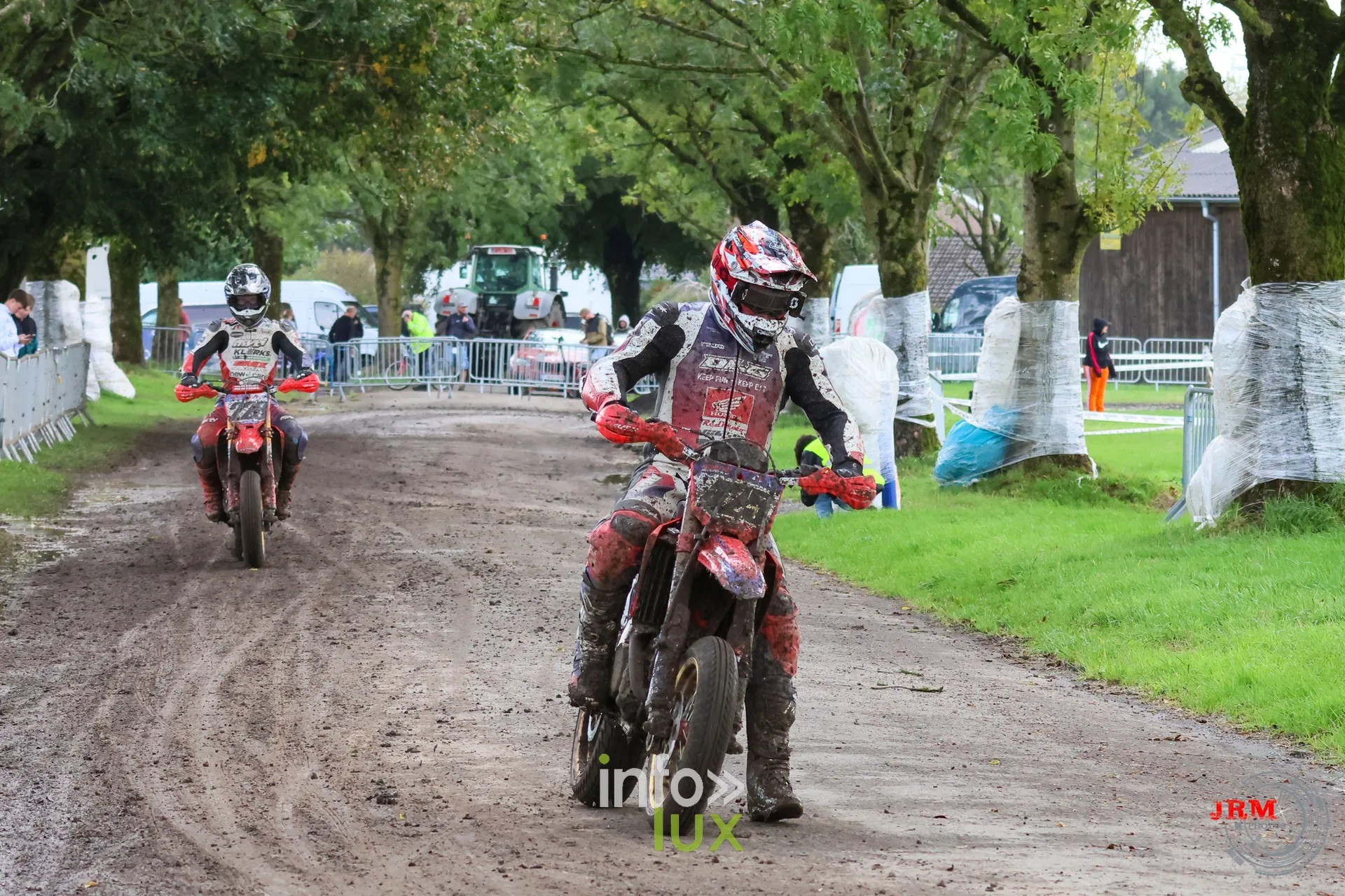 Supermotard de Battice 2026, Herve (province de Liège) : pilote couvert de boue dans l’allée arborée de la partie terre