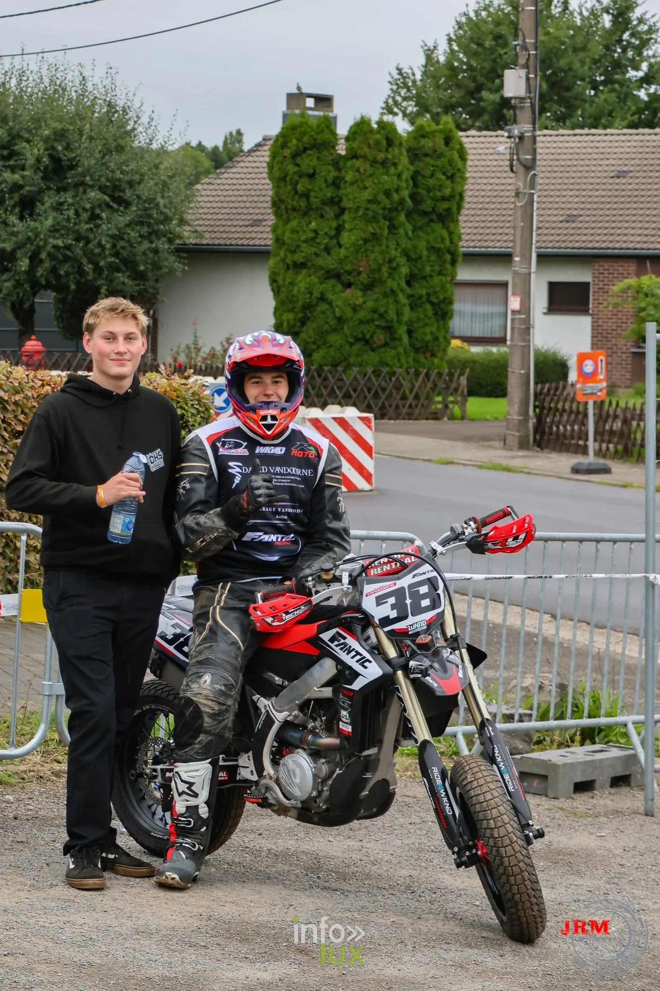 Supermotard de Battice 2026, Herve (province de Liège) : un pilote et sa moto n°38 dans le paddock, avec un accompagnant