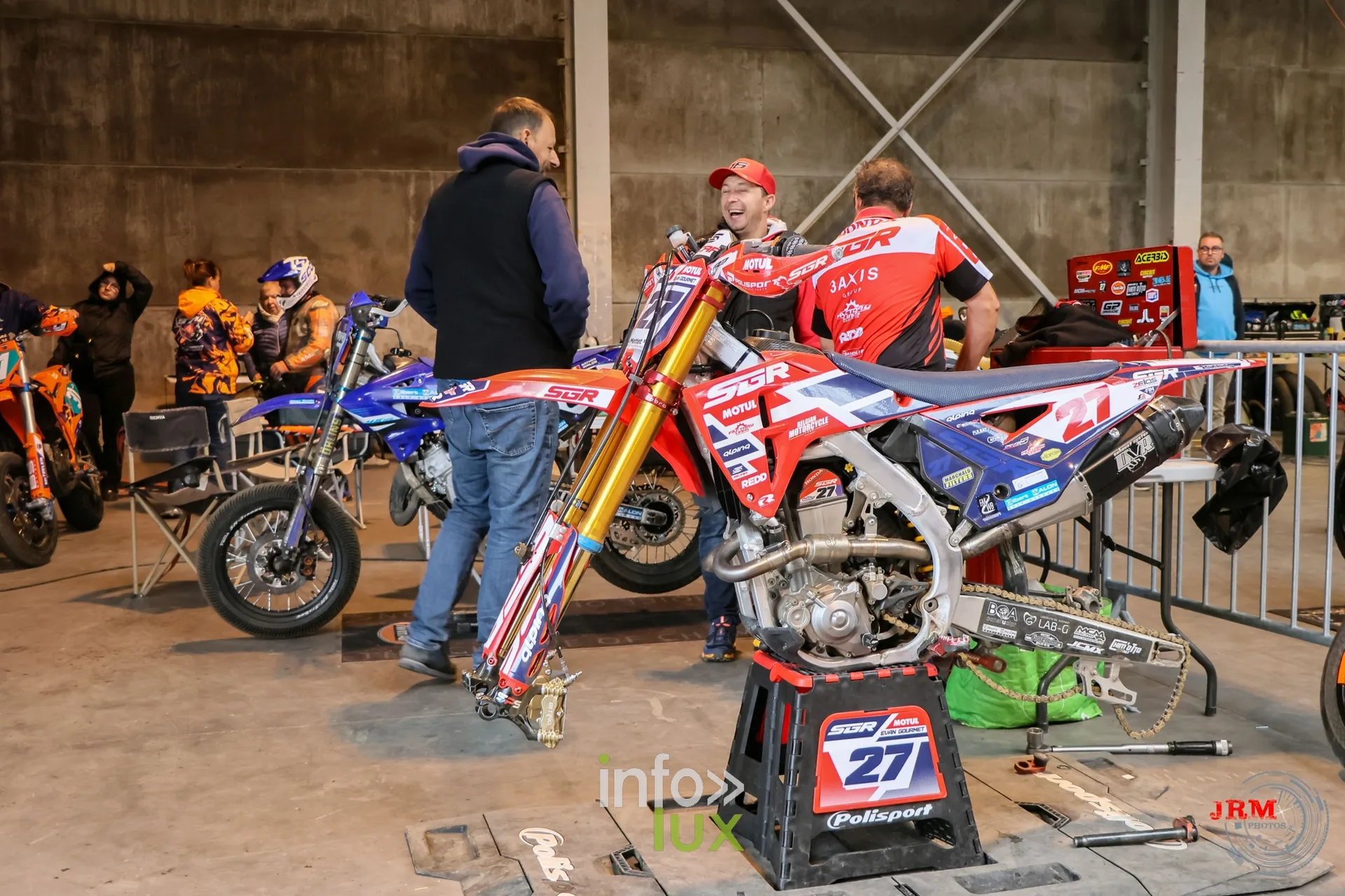 Supermotard de Battice 2026, Herve (province de Liège) : une moto sur béquille dans le paddock couvert, mécaniciens autour