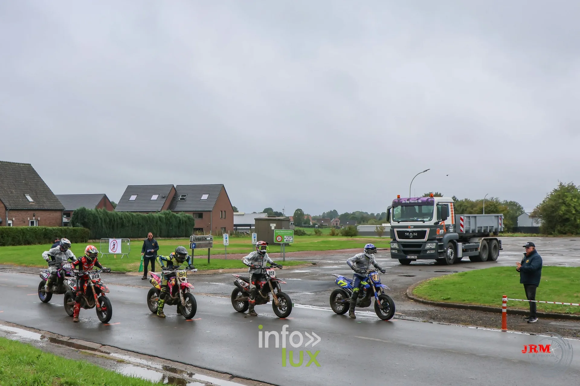 Supermotard de Battice 2026, Herve (province de Liège) : groupe de pilotes sur le parking asphalté, sous un ciel gris