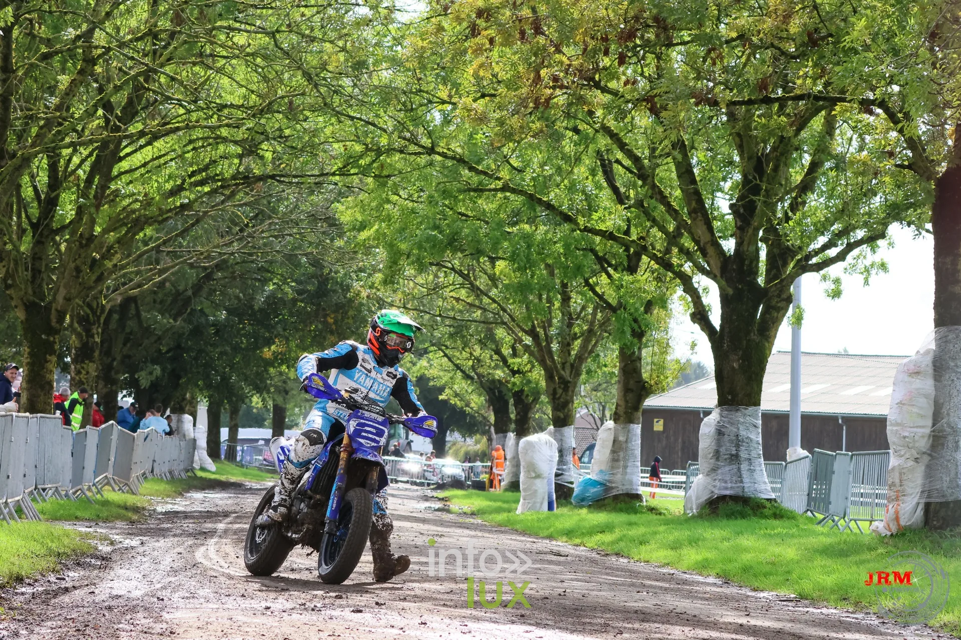 Supermotard de Battice 2026, Herve (province de Liège) : pilote sur une moto bleue dans l’allée arborée de la partie terre