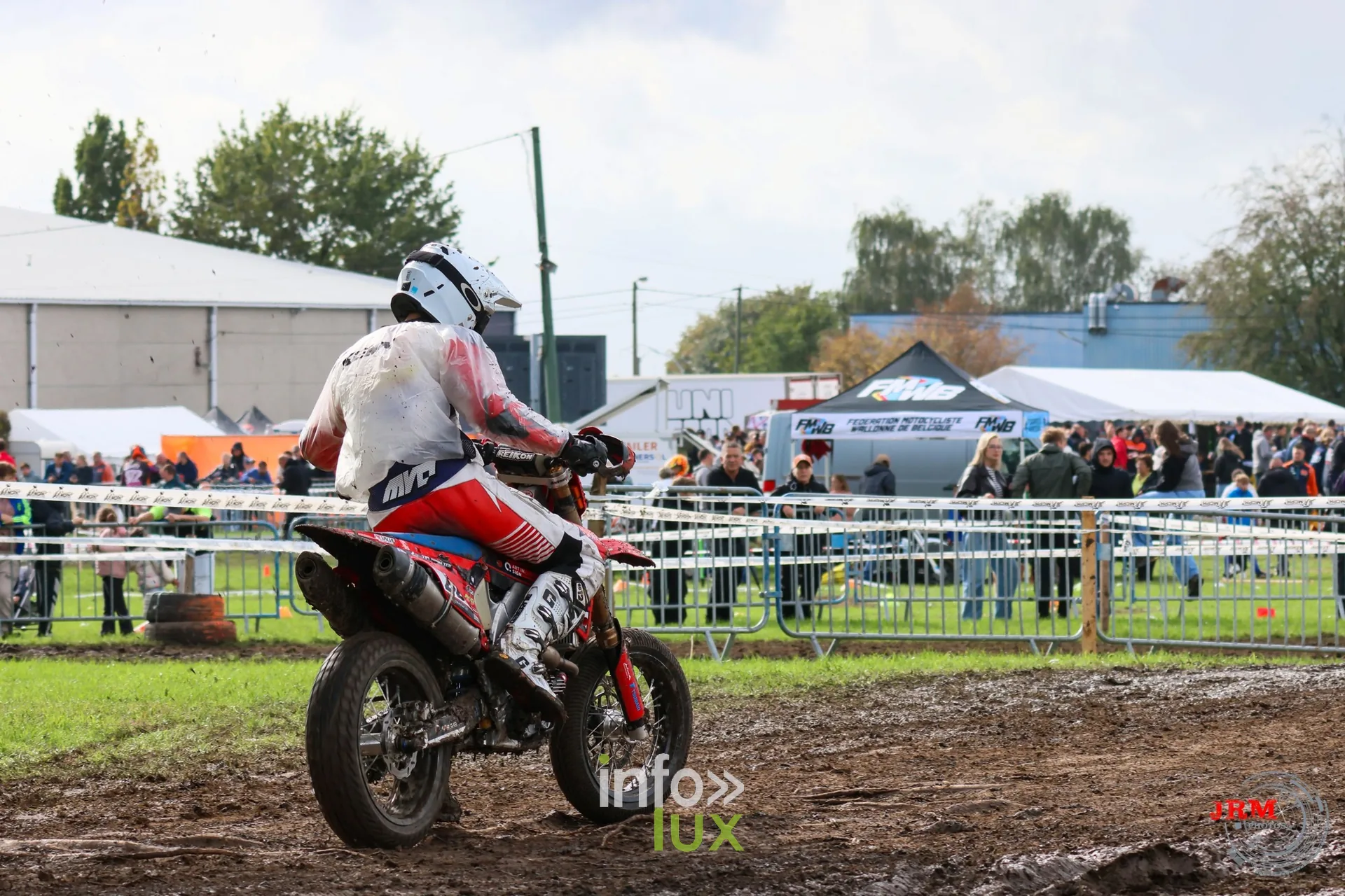 Supermotard de Battice 2026, Herve (province de Liège) : pilote en tenue blanche et rouge dans la partie terre, devant le public