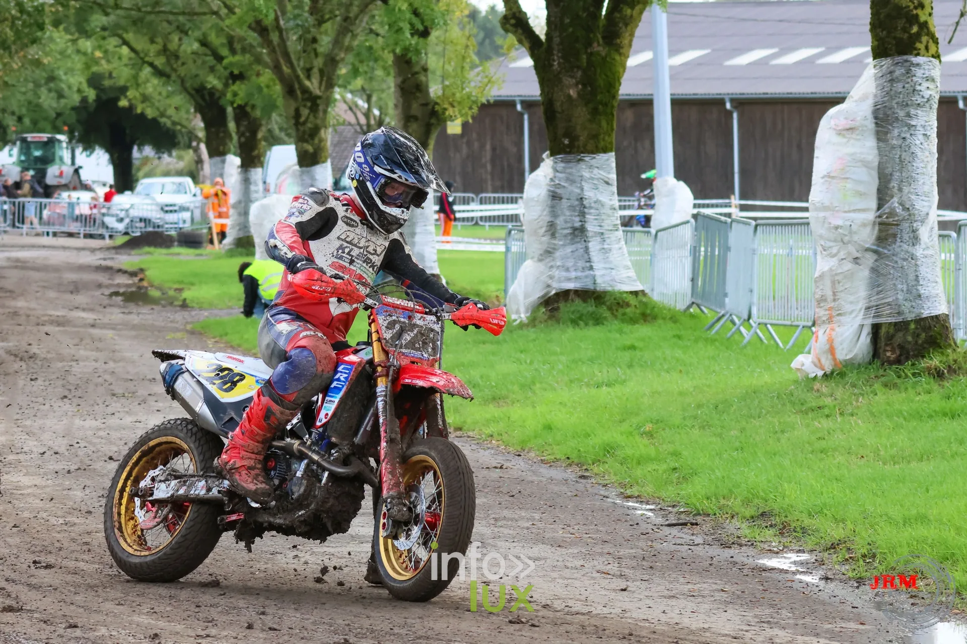 Supermotard de Battice 2026, Herve (province de Liège) : pilote sur une moto rouge dans l’allée arborée de la partie terre