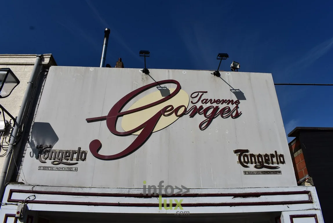 L’enseigne de la Taverne Georges L’enseigne de la Taverne Georges à Braine-l’Alleud, sur fond de ciel bleu