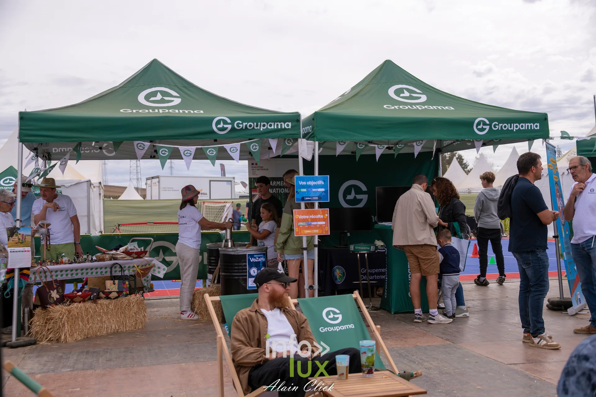 Tentes vertes Groupama et visiteurs installes sur des transats aux Terres de Jim