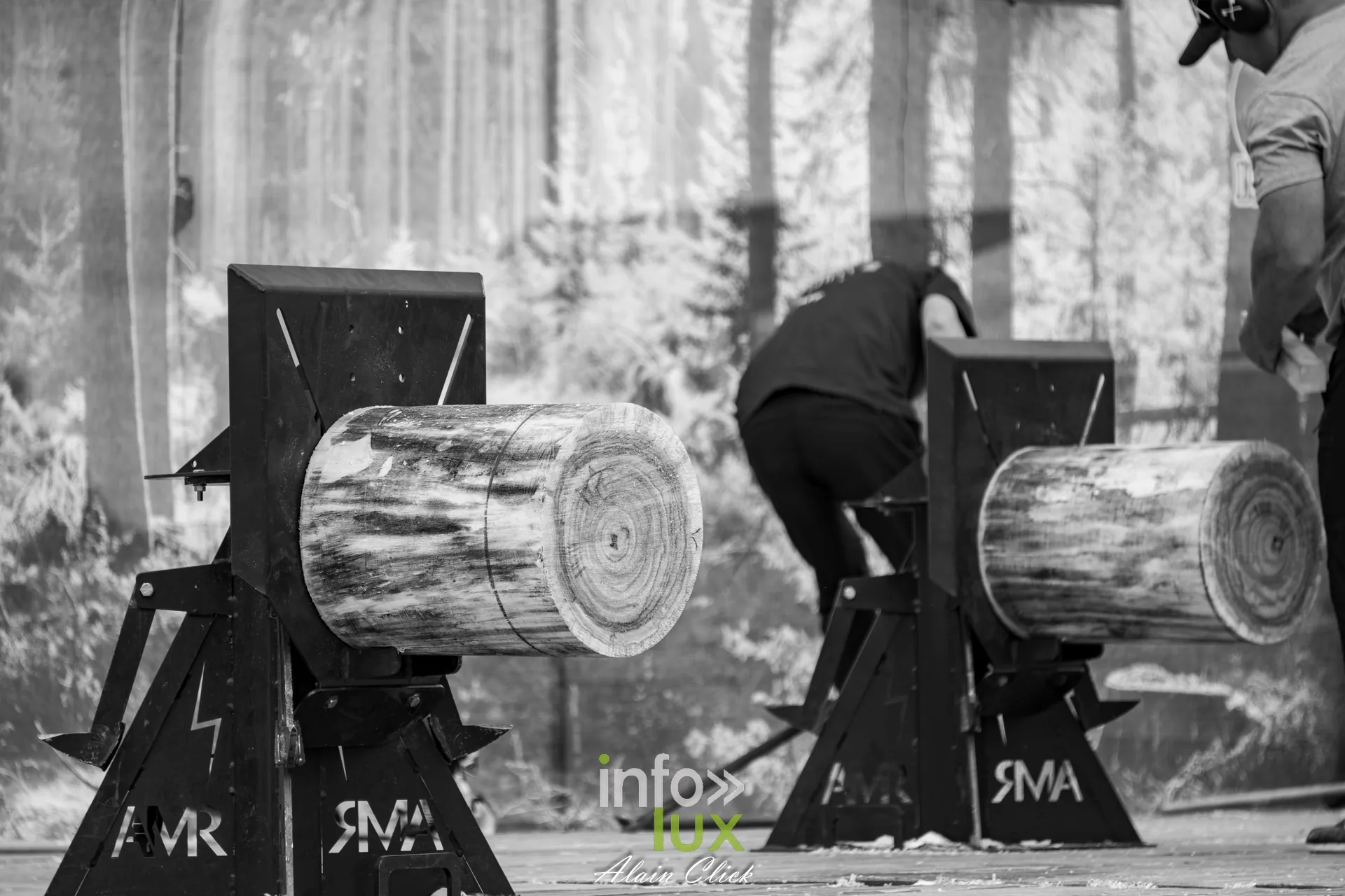 Bucheron sportif sciant un rondin a la tronconneuse en noir et blanc aux Terres de Jim