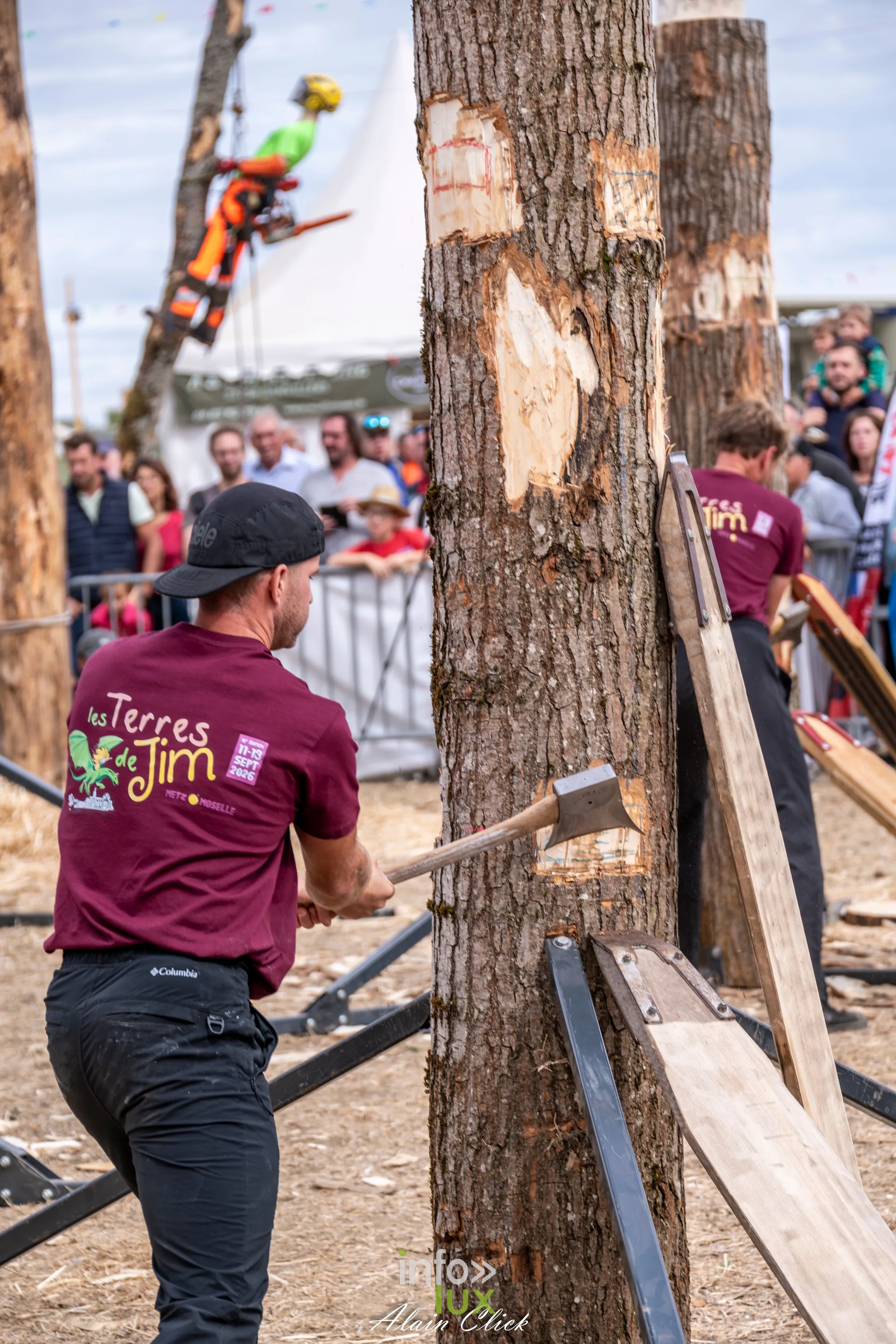 Bucheron sportif entaillant un tronc a la hache portant le tee-shirt Terres de Jim