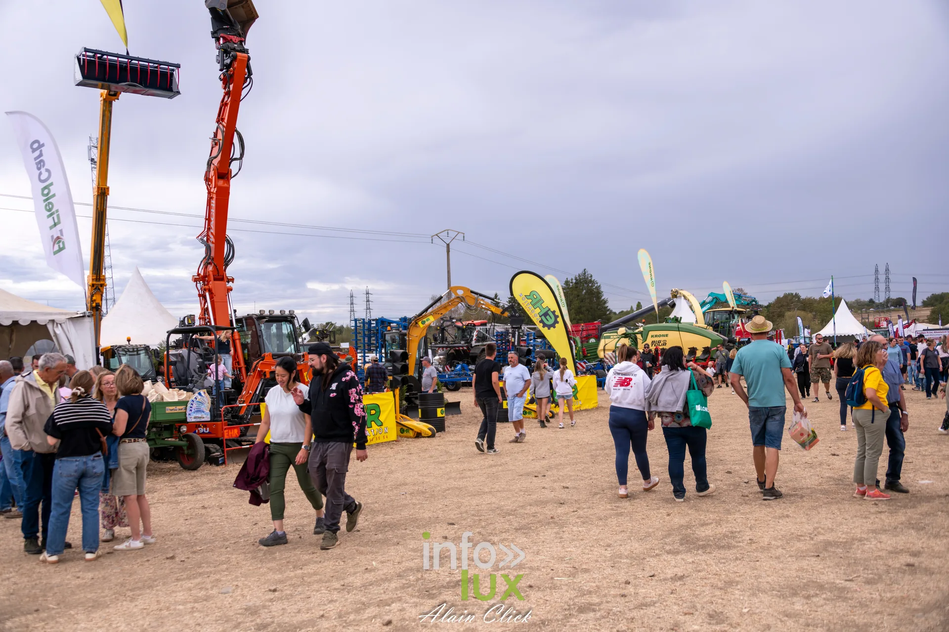 Allee du pole materiel agricole avec grue orange et visiteurs