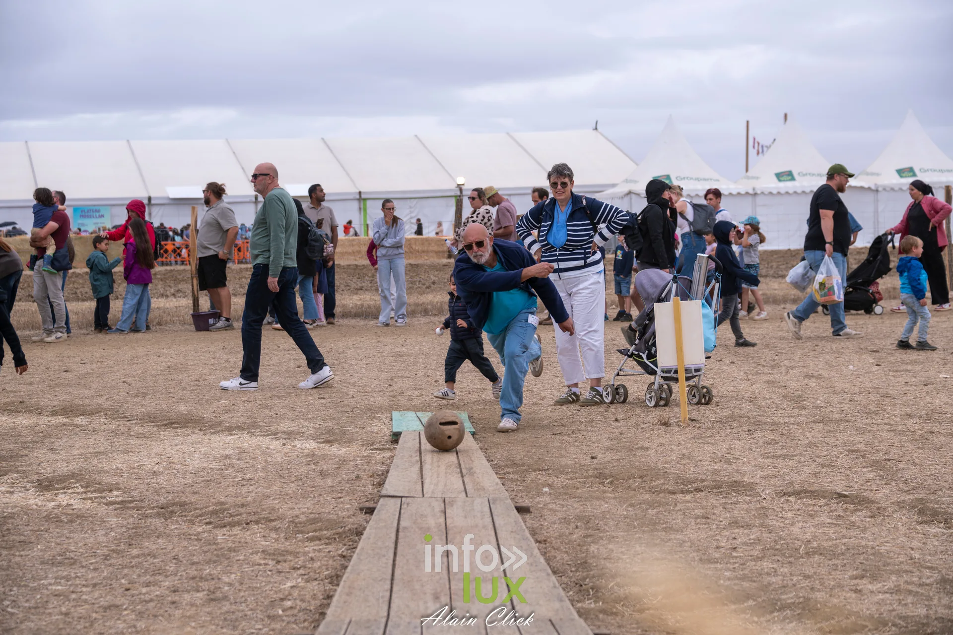 Visiteurs jouant a un jeu en bois dans les allees des Terres de Jim